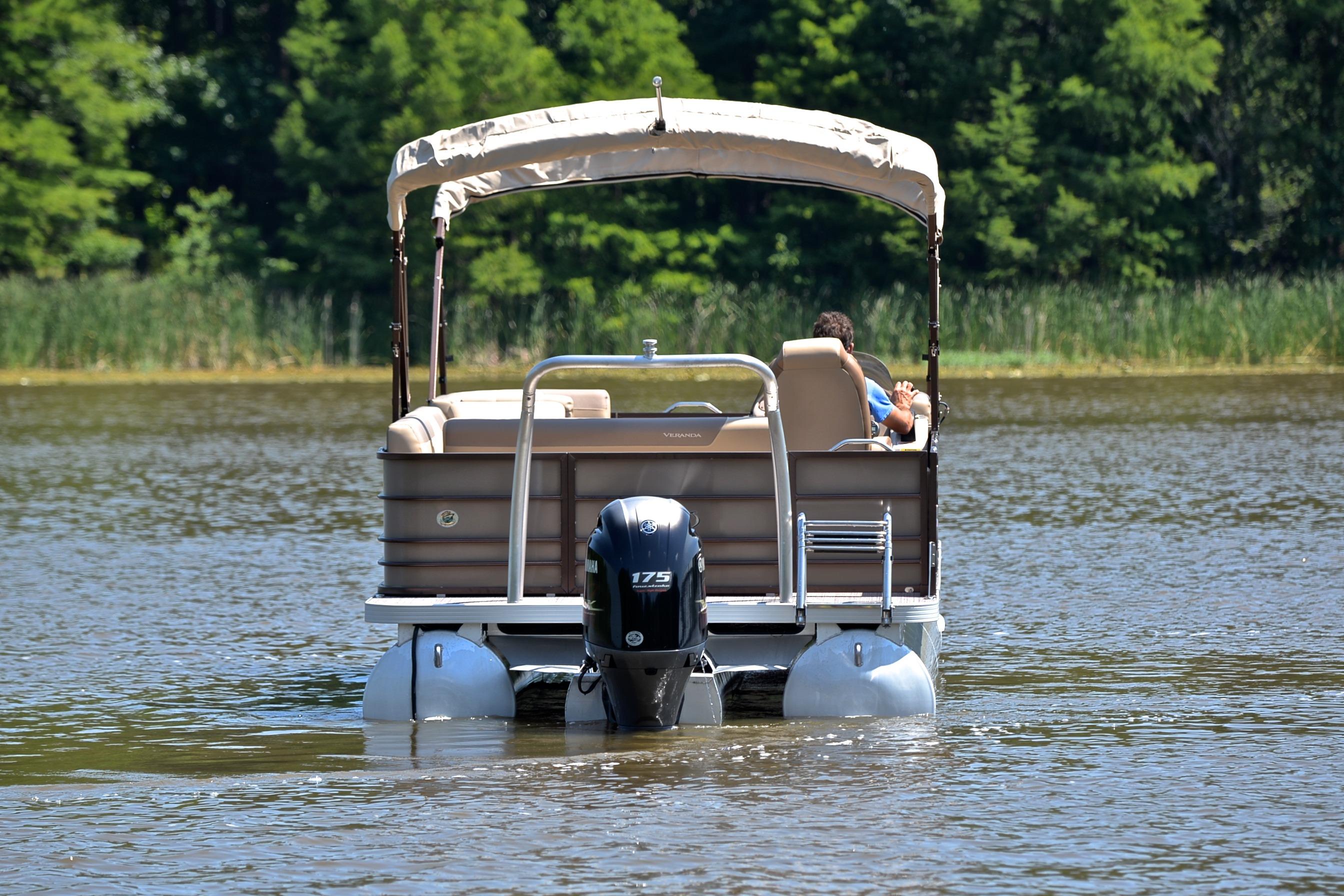 2020 Veranda VR22 pontoon boat on a calm lake with lush greenery.