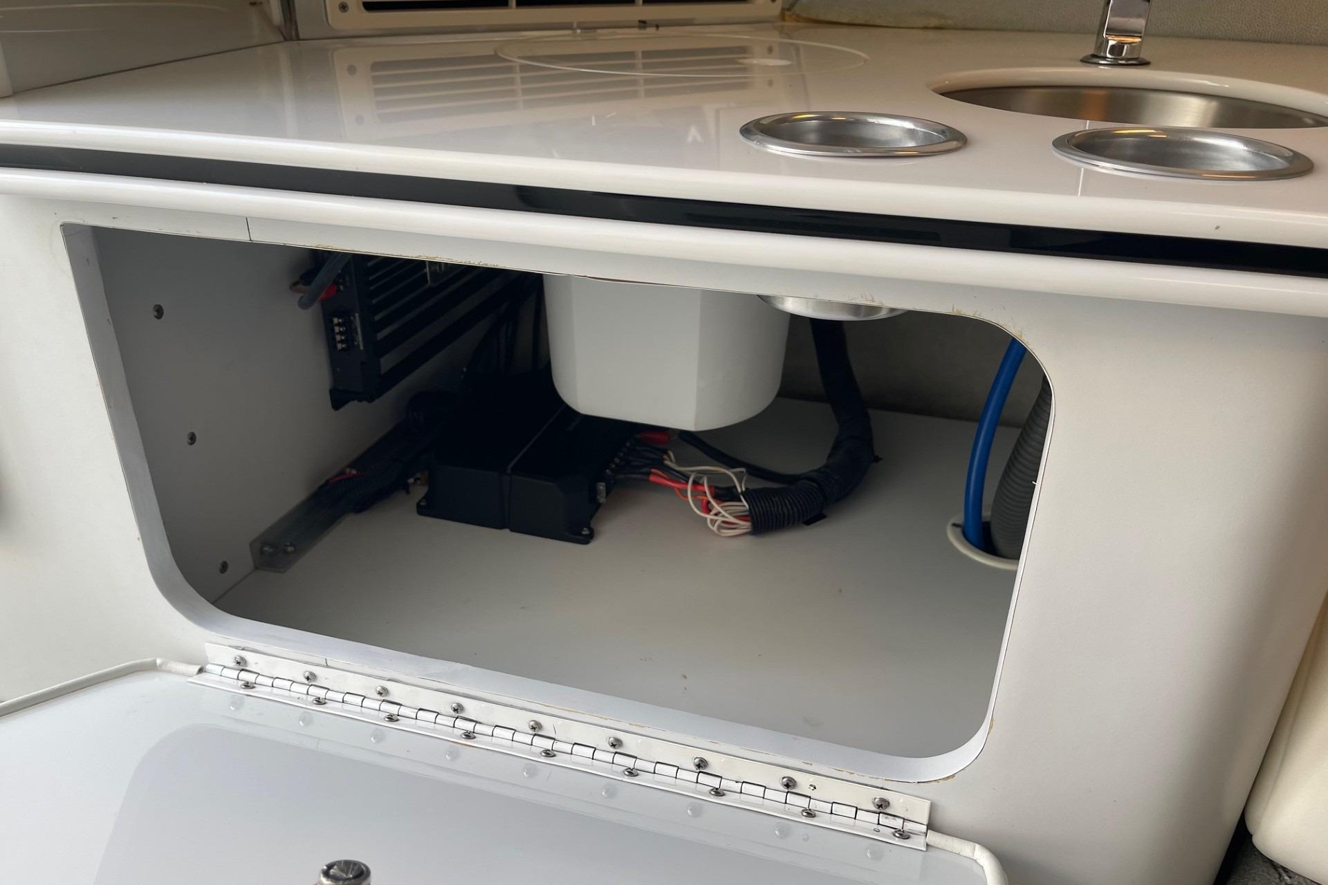 2004 Formula 382 FASTech boat interior storage compartment with wiring and sink.