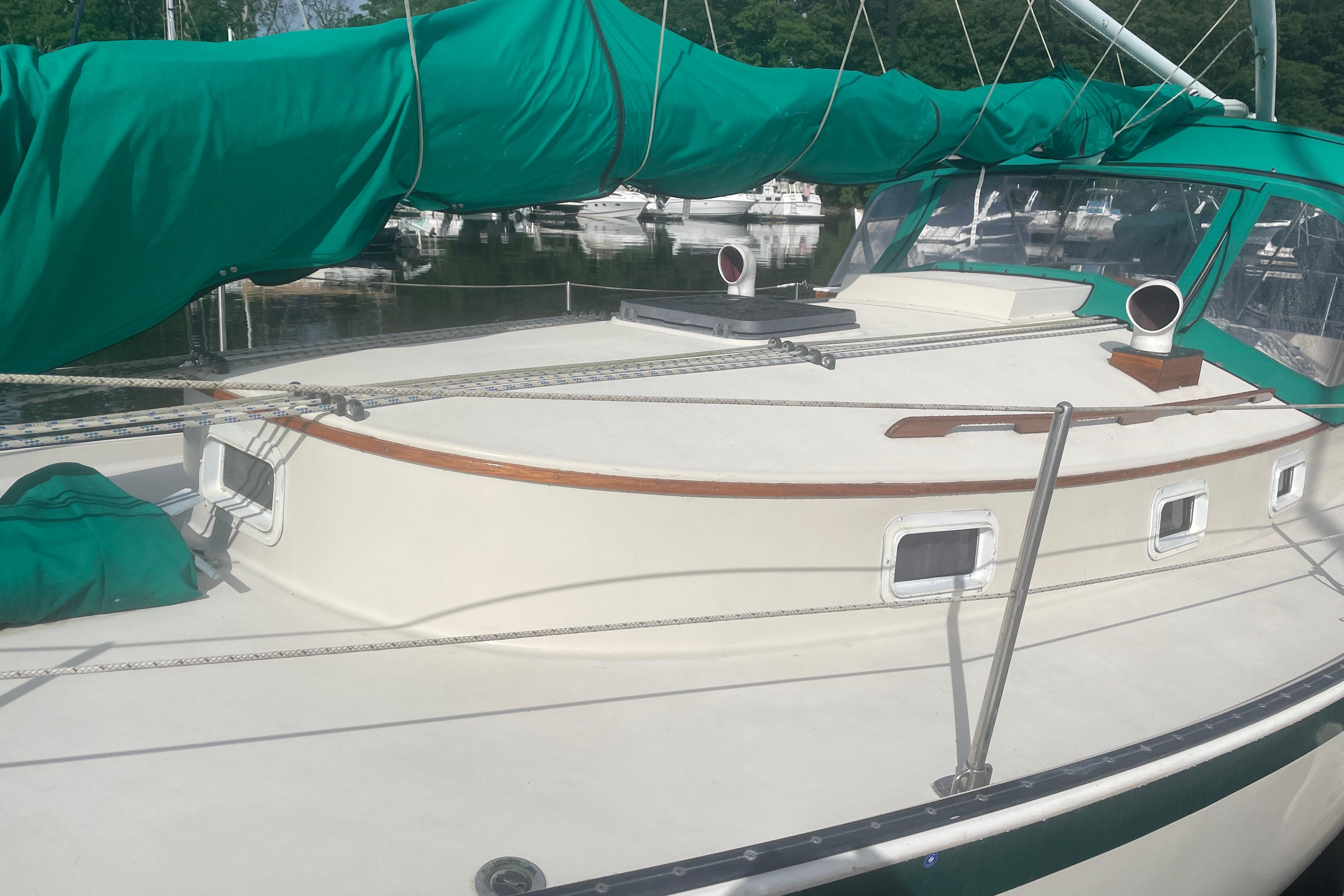 1981 Nonsuch 30 Classic sailboat with green sail cover, docked in a marina.
