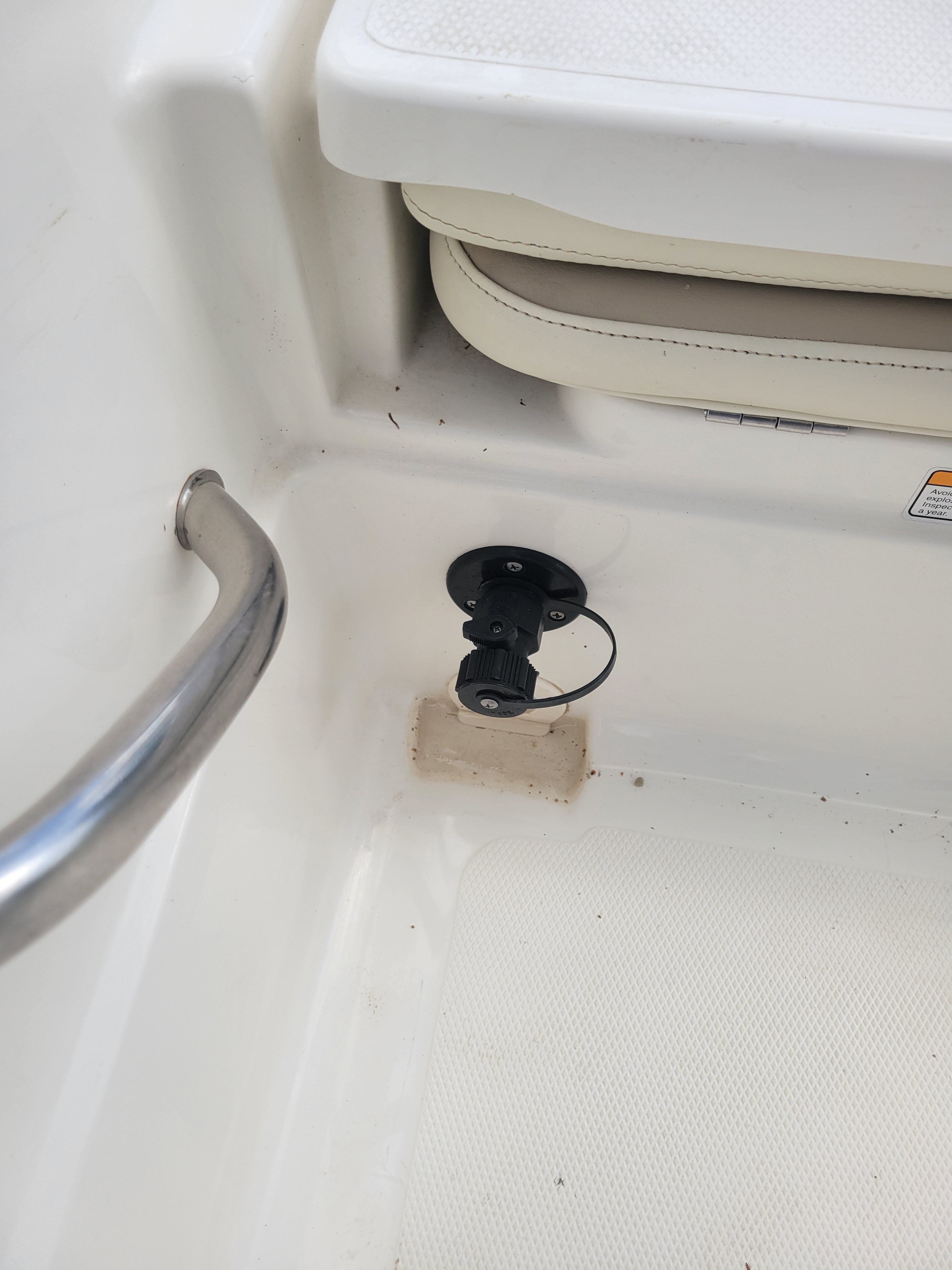 Close-up of a boat interior with a seat and handrail.