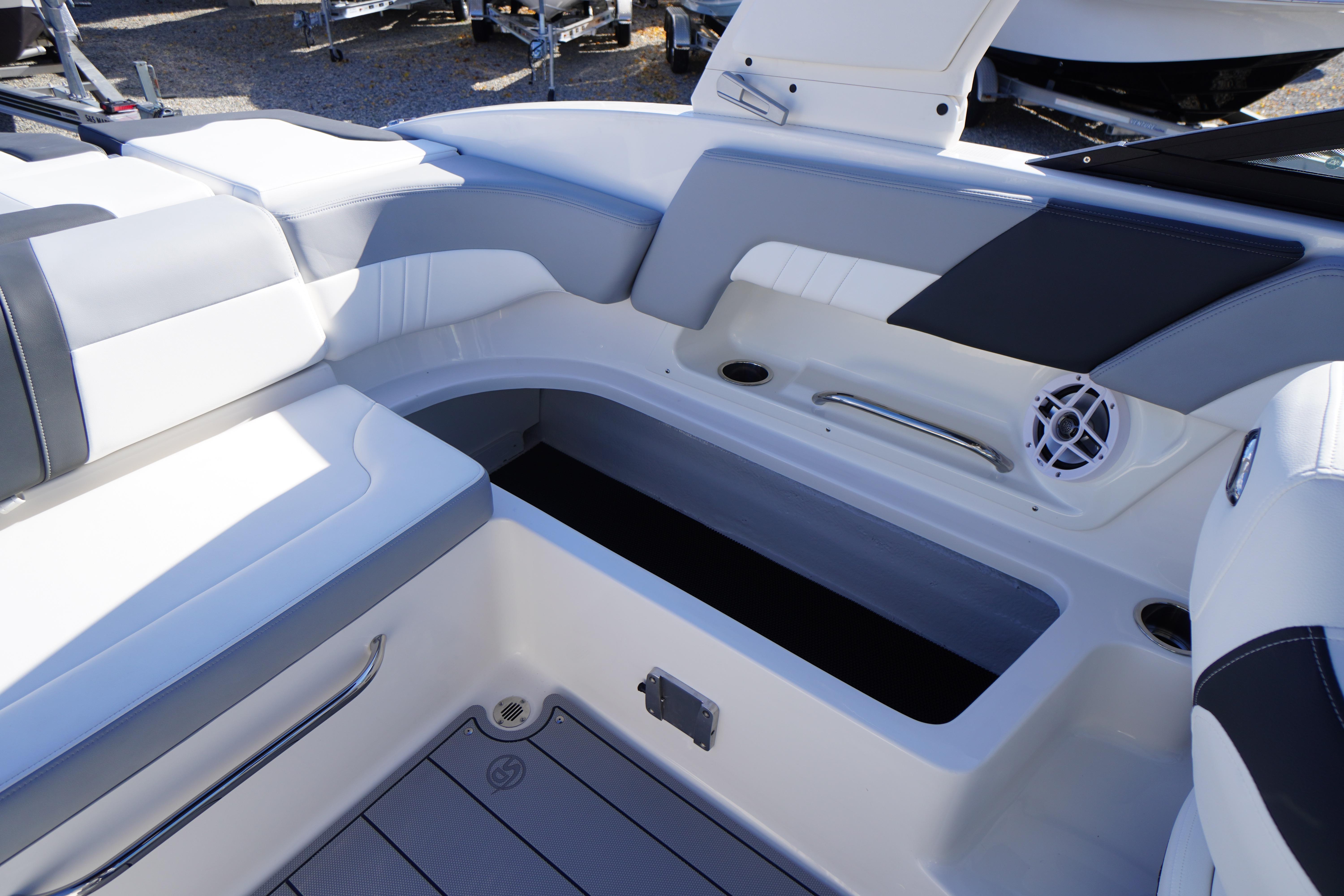 2026 Chaparral 23 SSi OB boat interior with white seating and storage compartment.