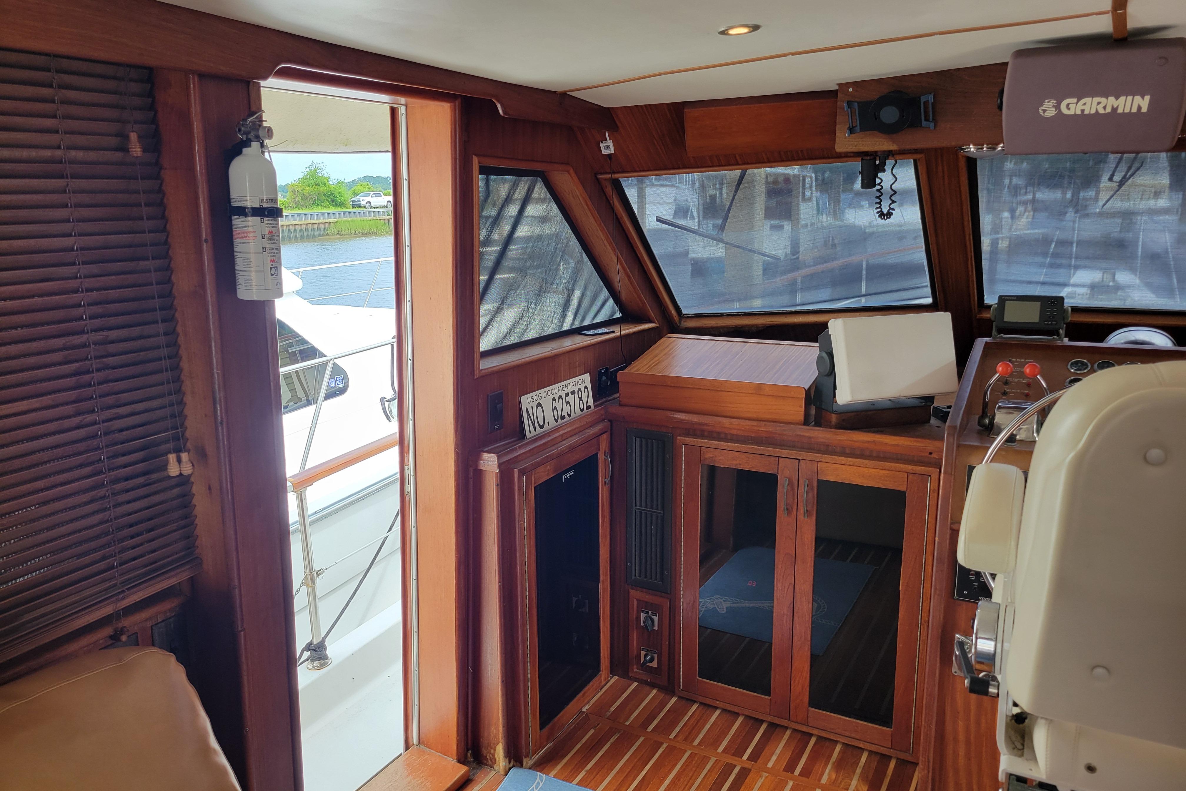Interior of 1980 Hatteras 53 Yacht Fisherman with wooden cabinetry and navigation equipment.