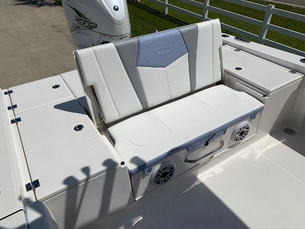 2024 Robalo 266 Cayman boat seating area with storage and speakers.