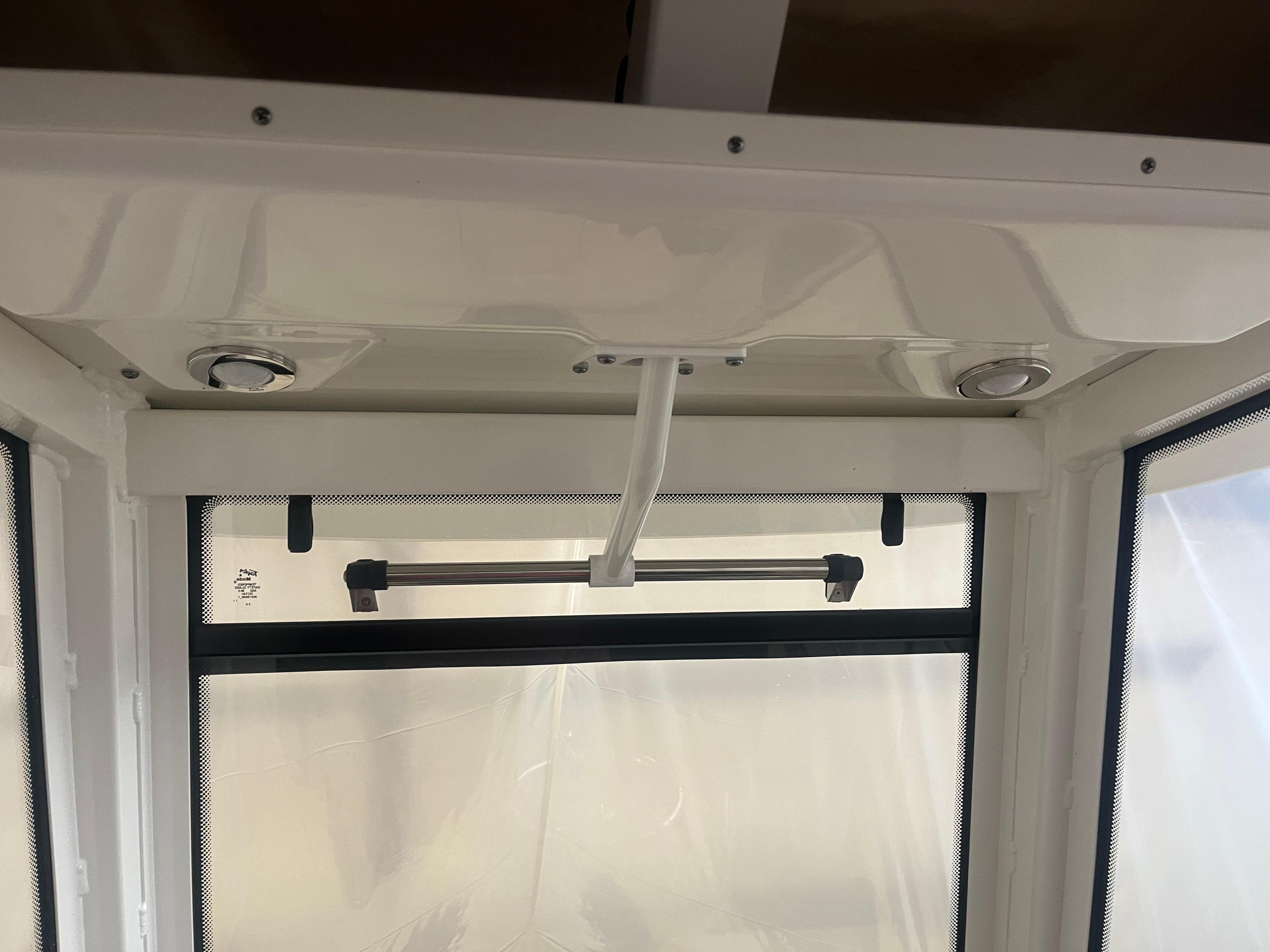 Interior view of 2021 Robalo R272 Center Console boat with window and ceiling details.