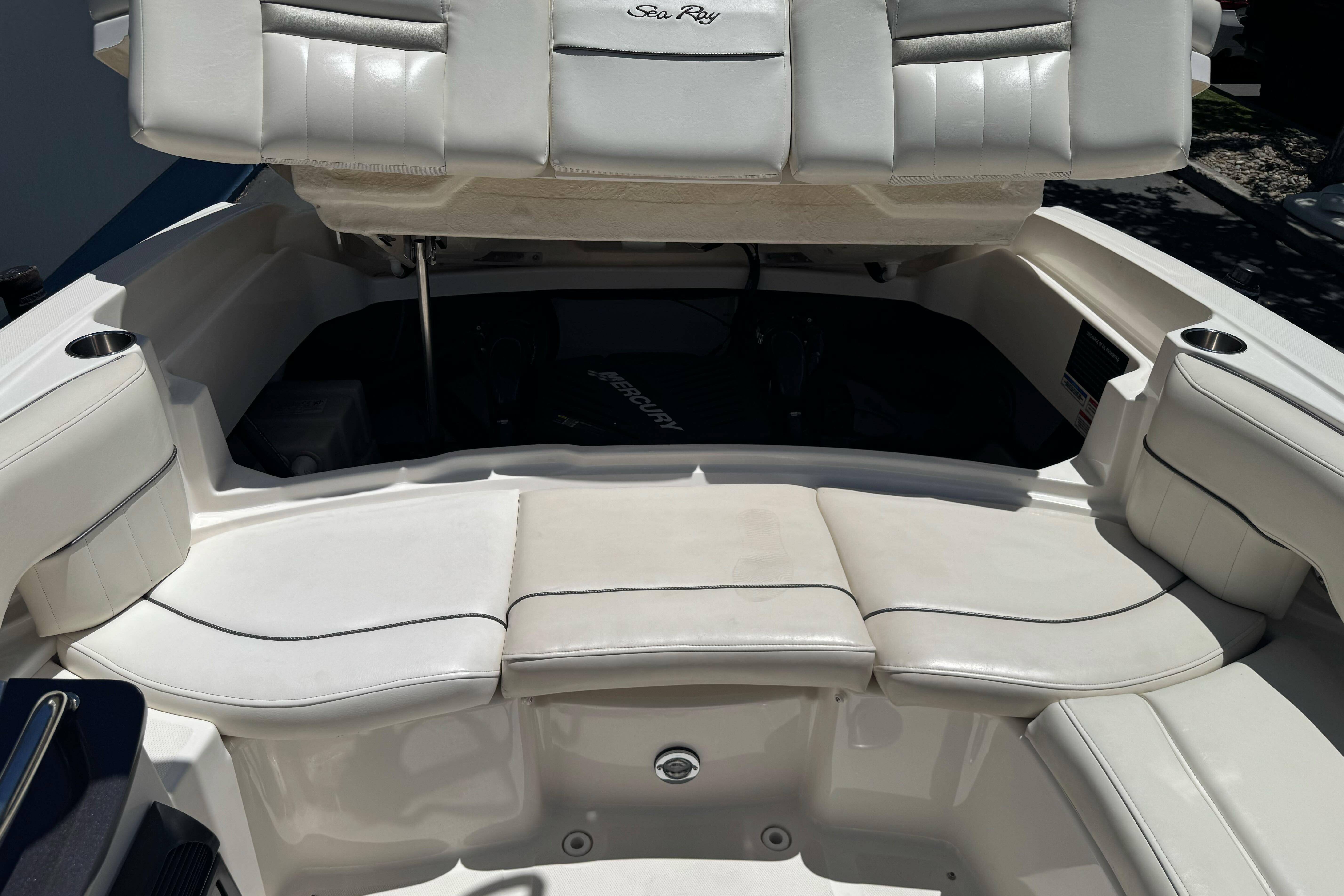 2007 Sea Ray SLX 250 boat interior with white cushioned seating and open storage compartment.