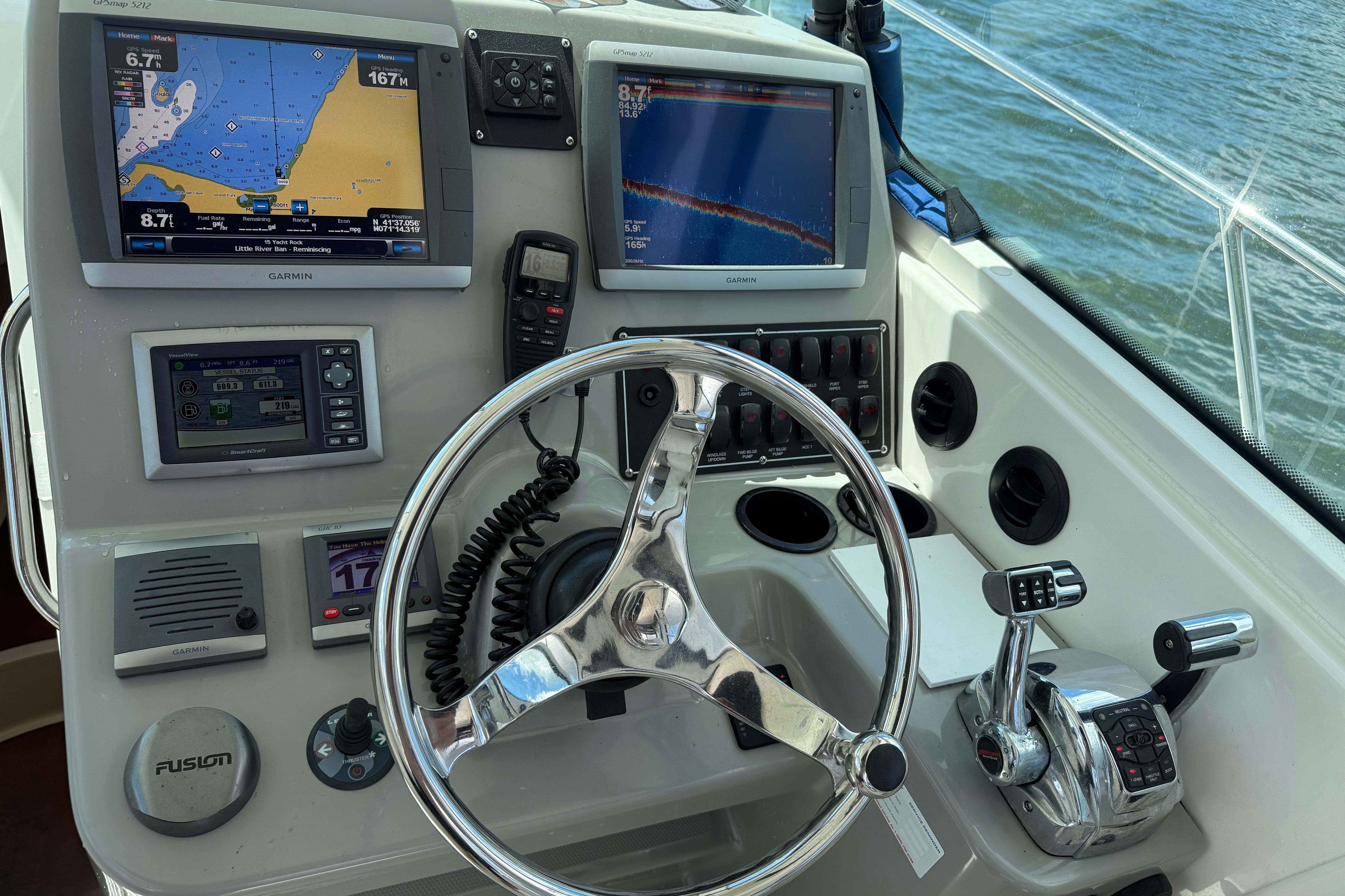 Control panel of a 2013 Boston Whaler 315 Conquest boat with navigation screens.