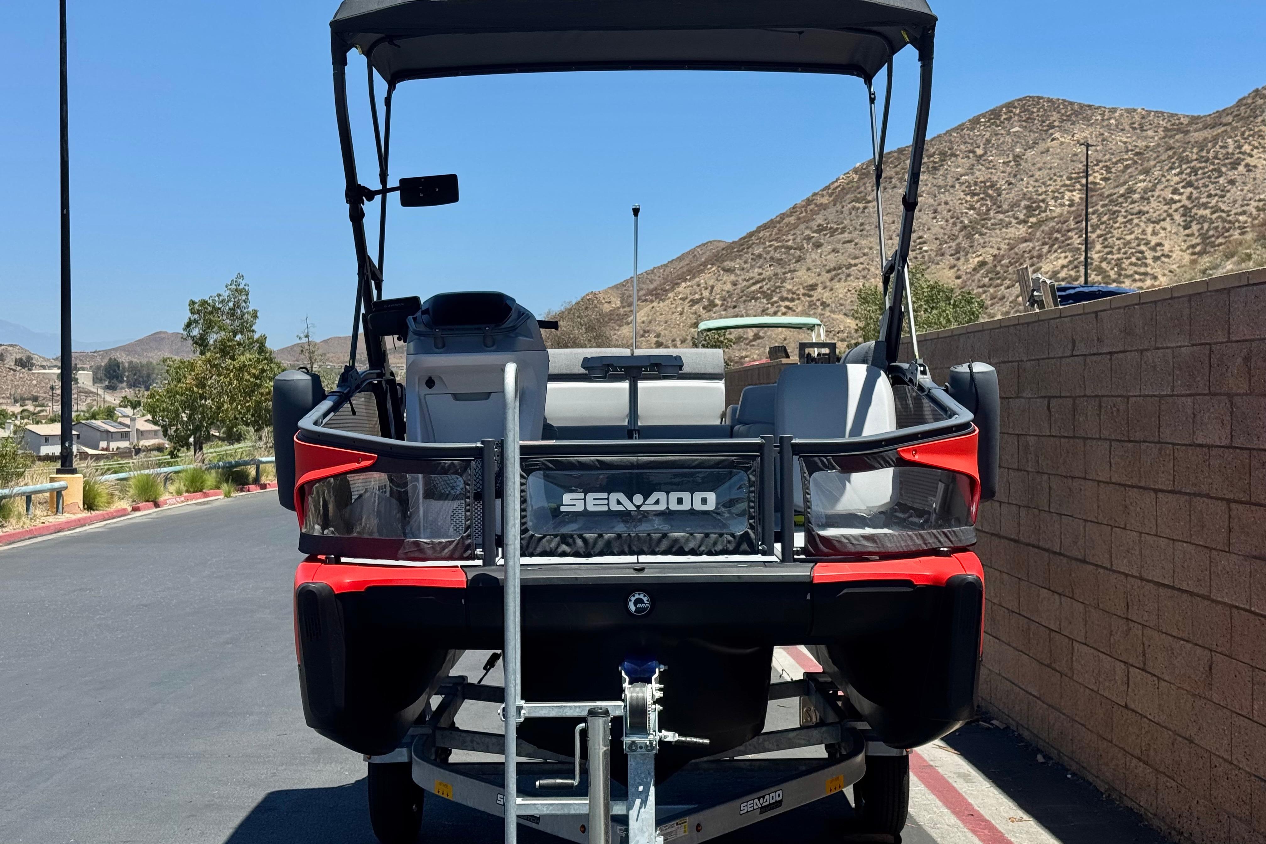 2024 Sea-Doo Switch Compact on trailer, parked near scenic hills and clear sky.