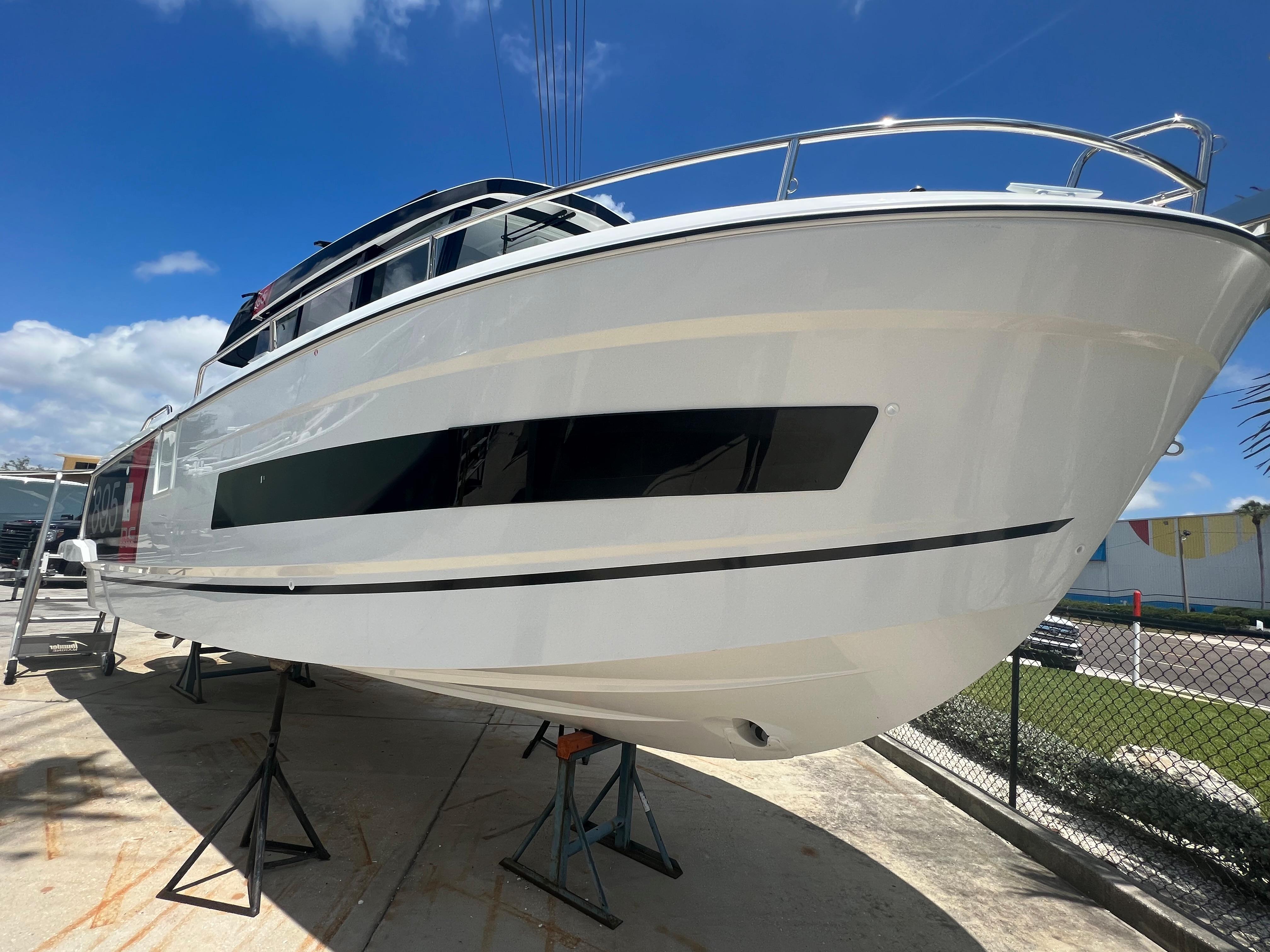 2024 Jeanneau NC Sport 895 boat on stands under a clear blue sky.
