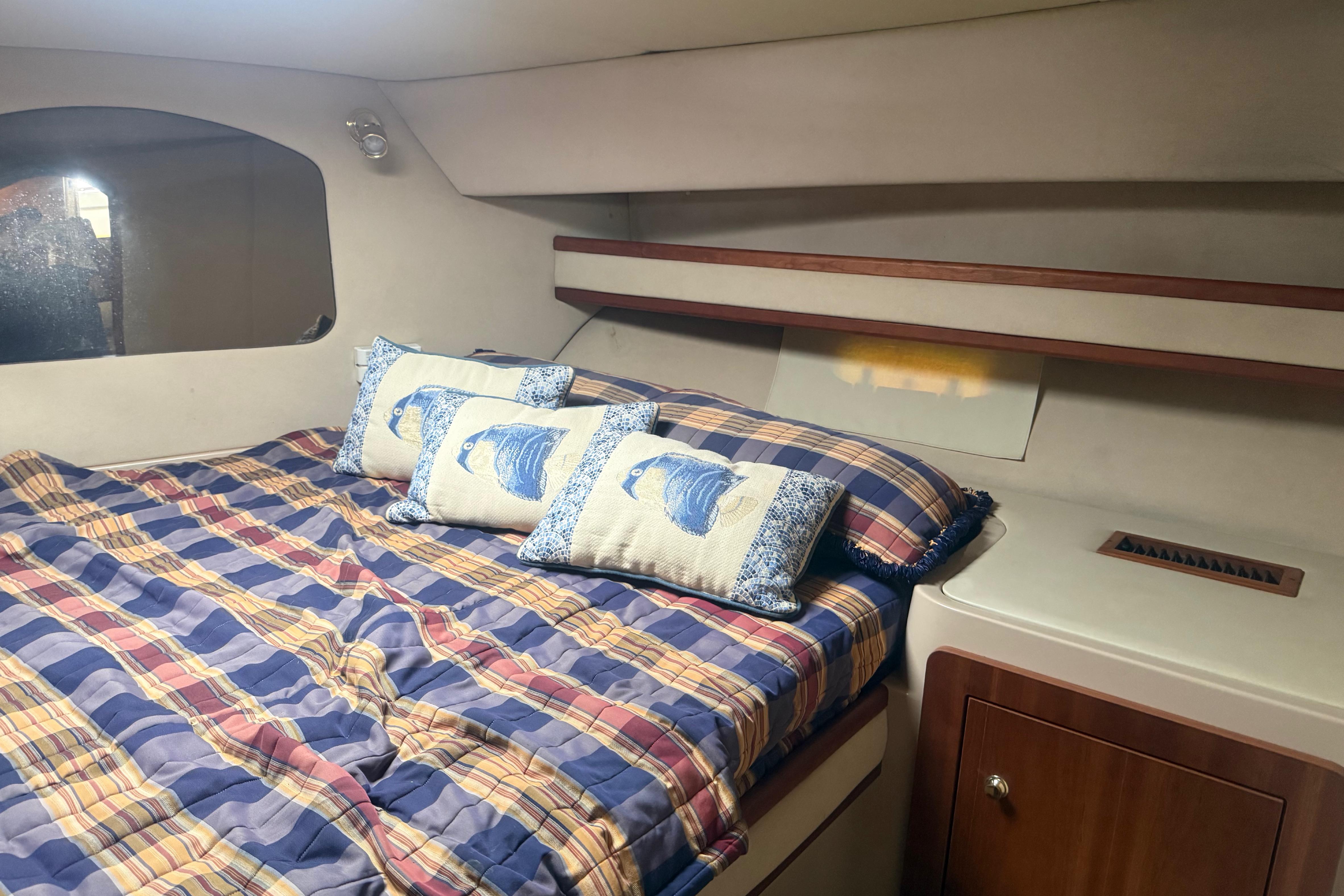 2003 Cruisers 3752 yacht cabin with plaid bedding and fish-themed pillows.