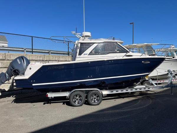2025 Cutwater C-248 C Coupe boat on trailer, parked outdoors under clear blue sky.