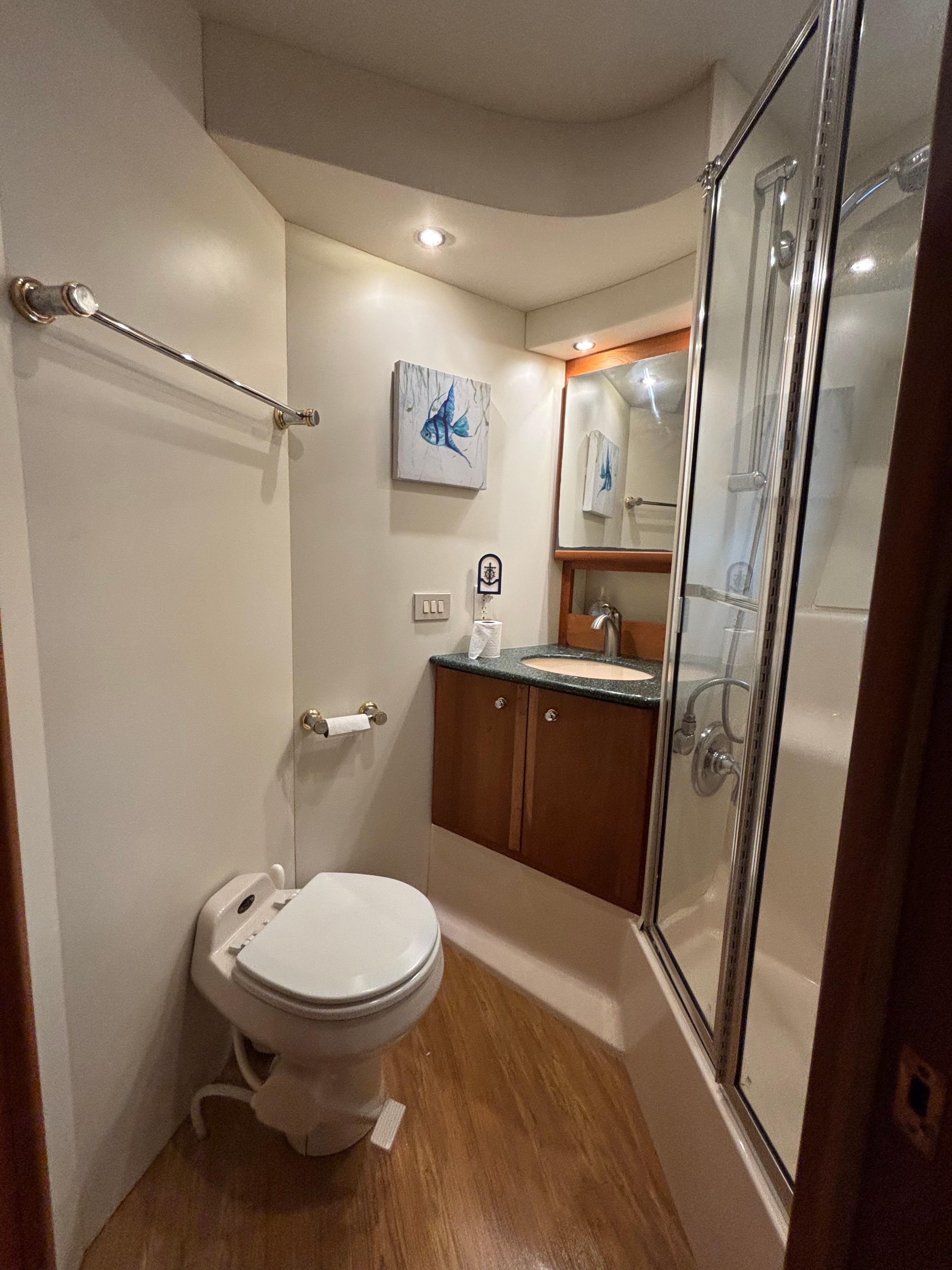 Bathroom interior of 2000 Silverton 453 Motor Yacht with shower and wooden flooring.
