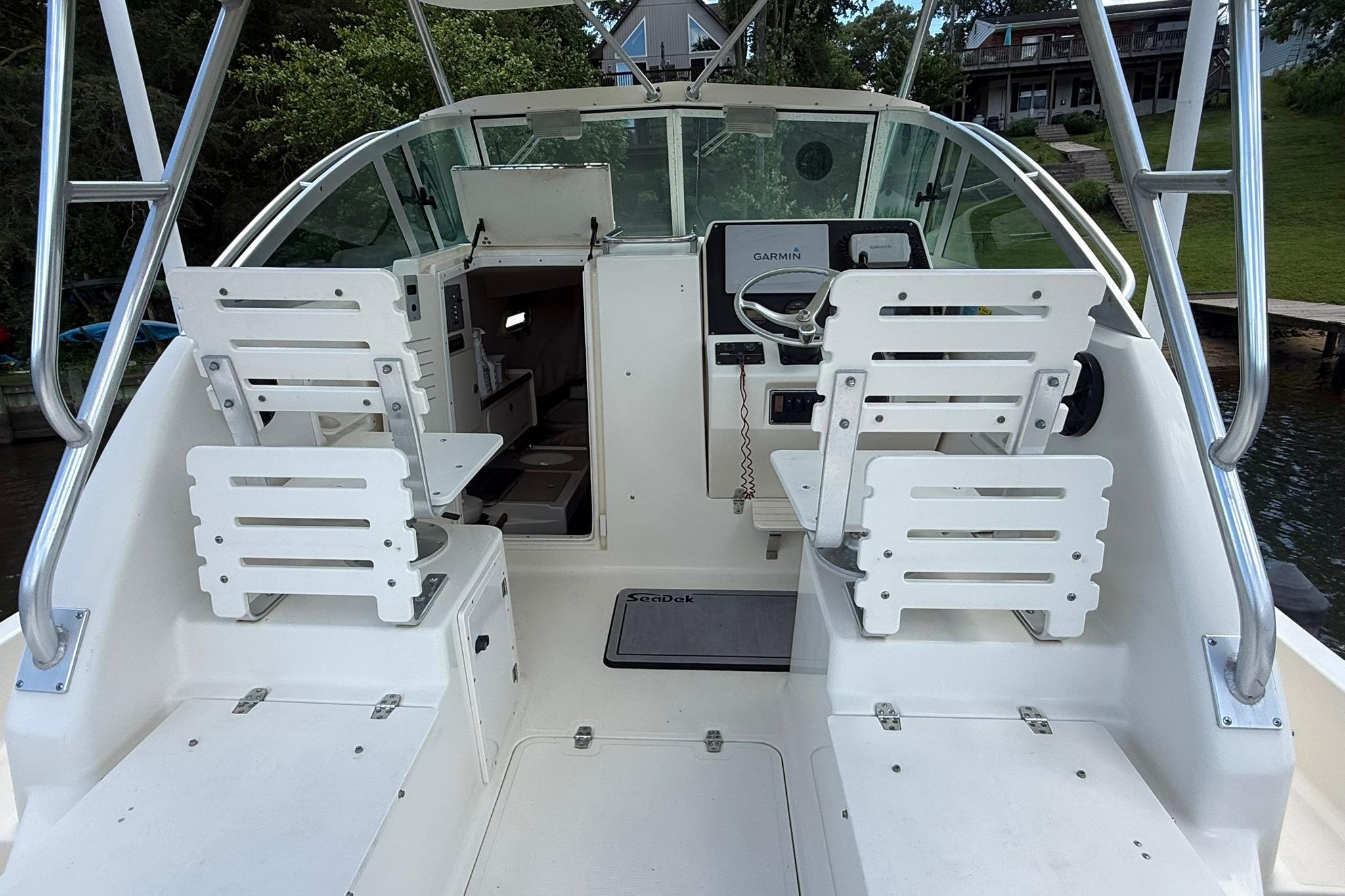 2003 Pursuit 2870 Walkaround boat interior with helm, seating, and Garmin navigation system.