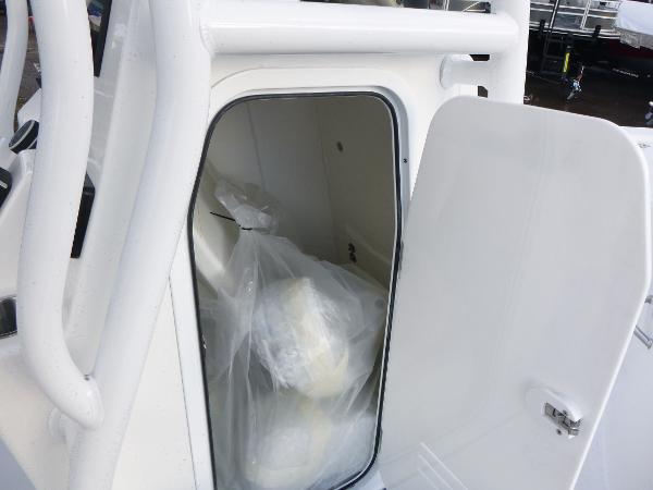 2025 Sea Pro 230 Bay boat storage compartment with open door, showing interior details.