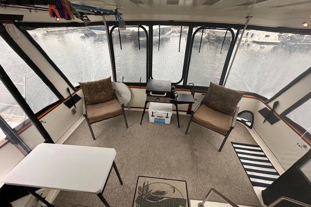 1989 Sea Ray 380 Aft Cabin interior with chairs, table, and marina view.