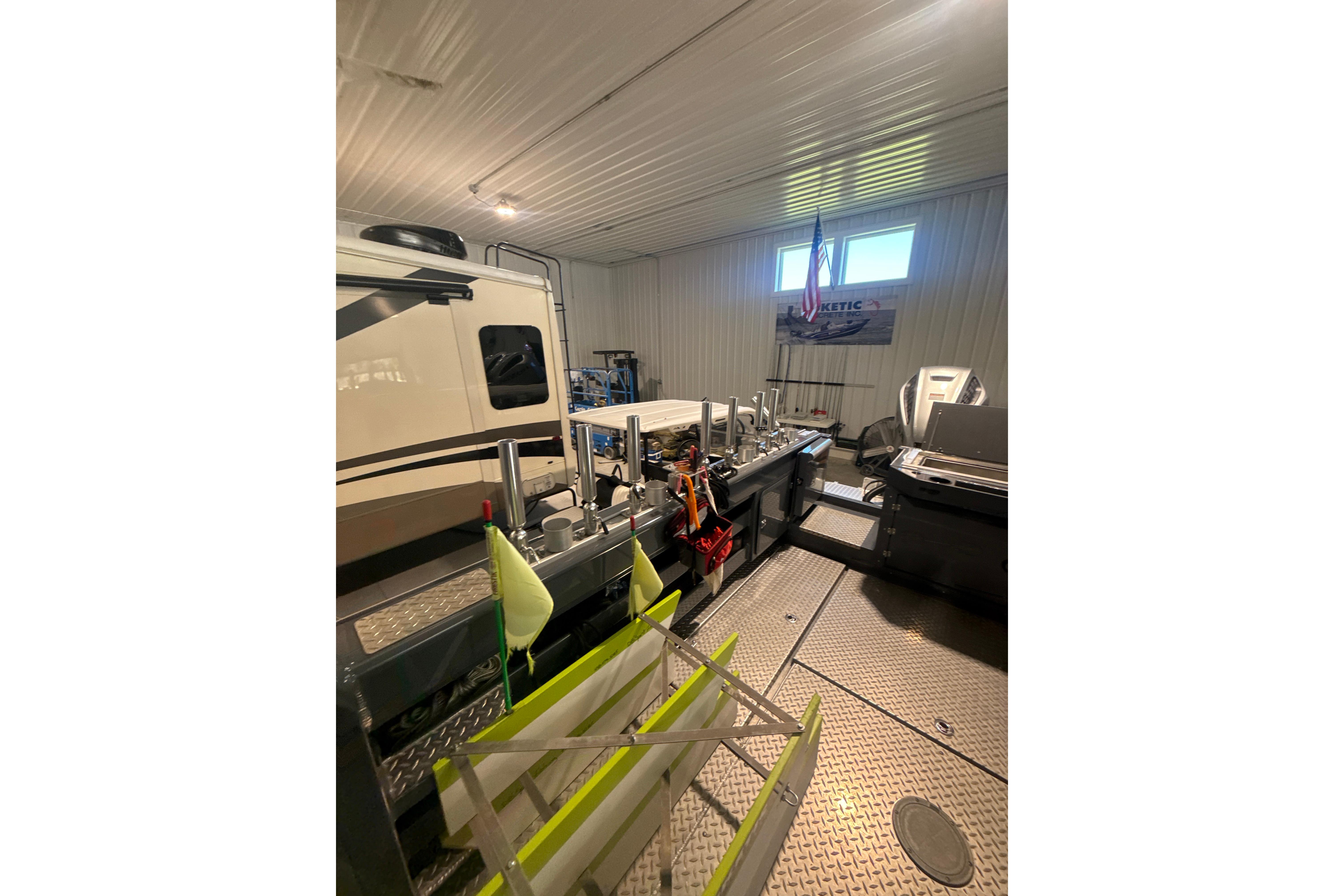 2022 Hewescraft 270 Alaskan Hardtop in a garage with equipment and tools.
