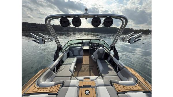 2023 MasterCraft XT22 boat interior with sleek seating and advanced sound system on a calm lake.