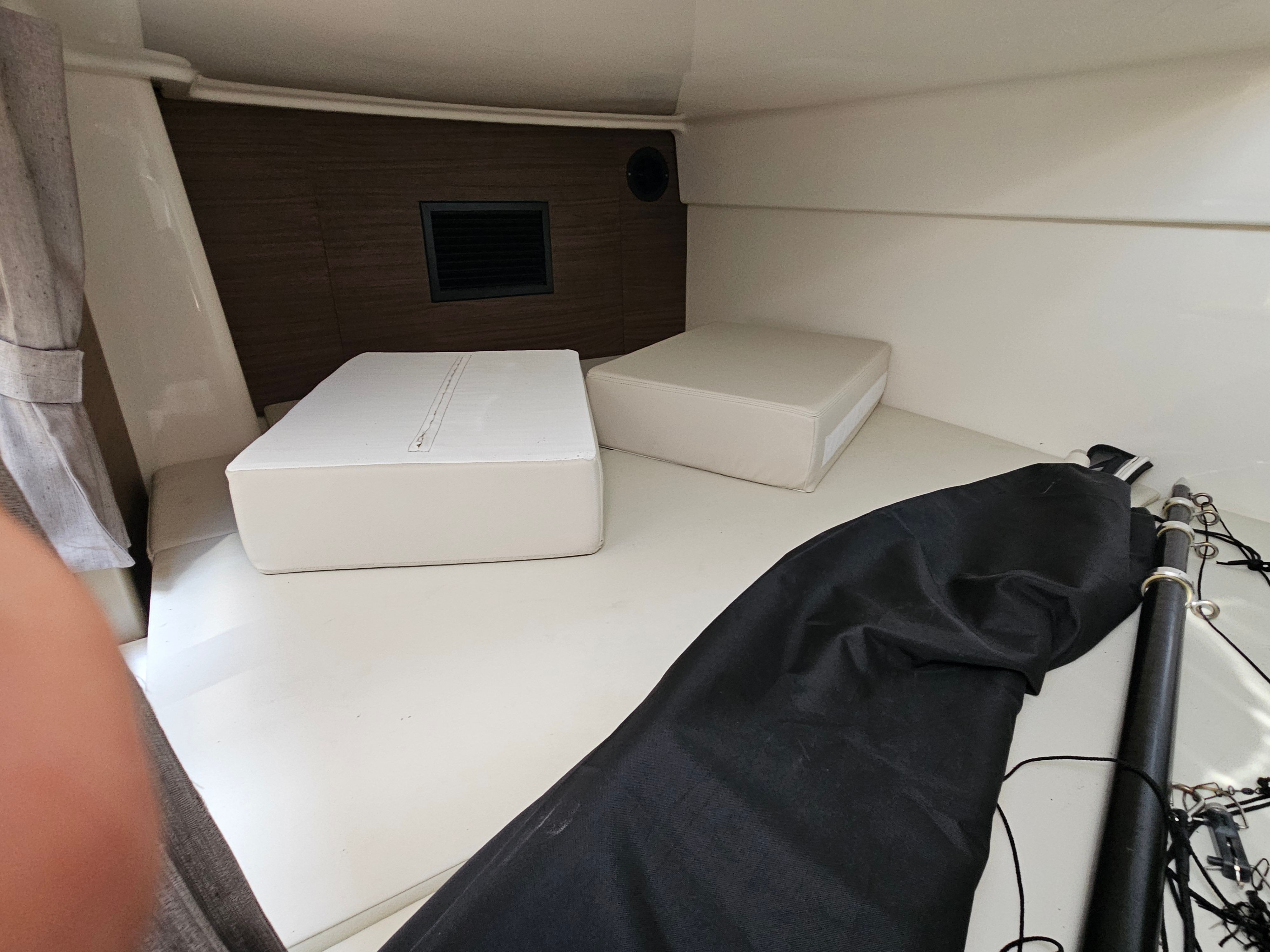 Interior of a Boston Whaler 325 Conquest with white cushions and a black sail.