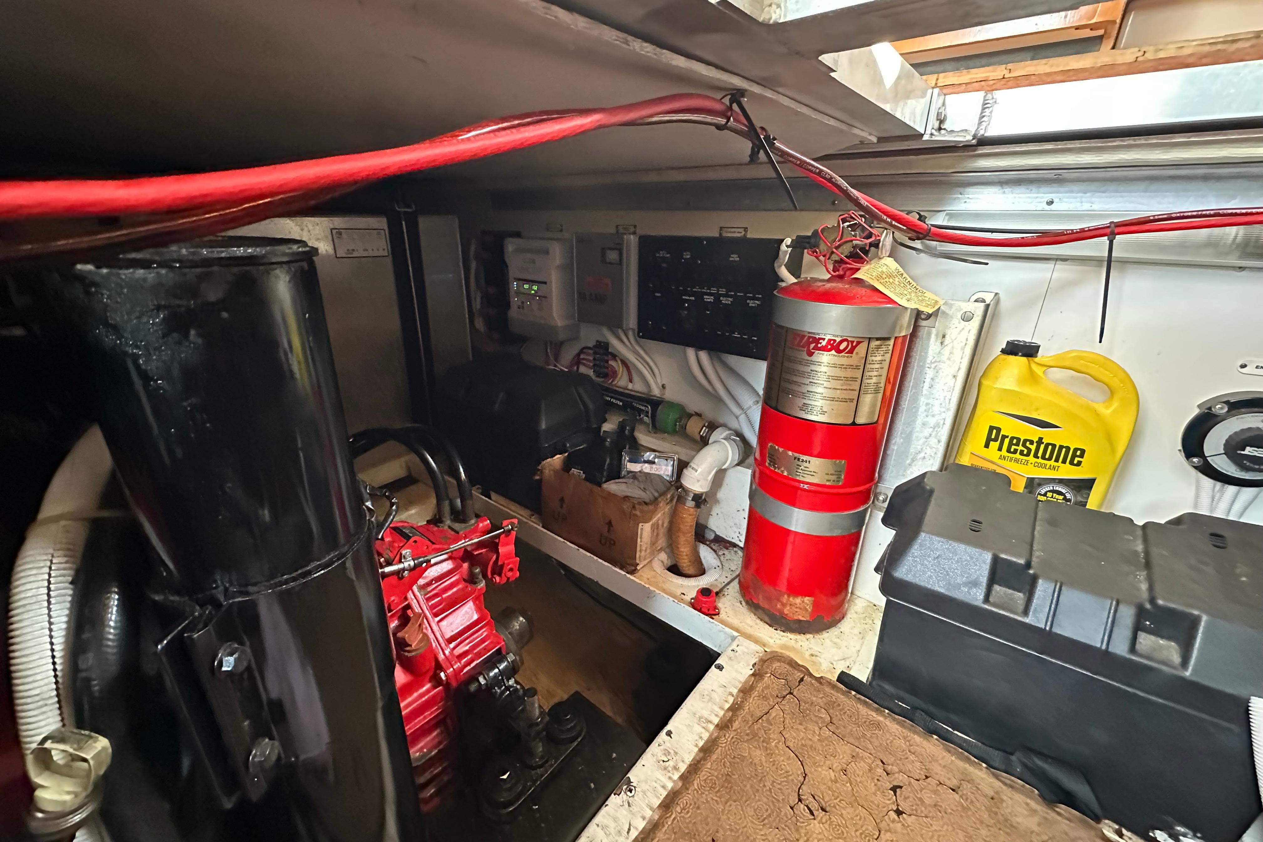 Engine room of a 2005 Carver 36 Super Sport with fire extinguisher and coolant container.
