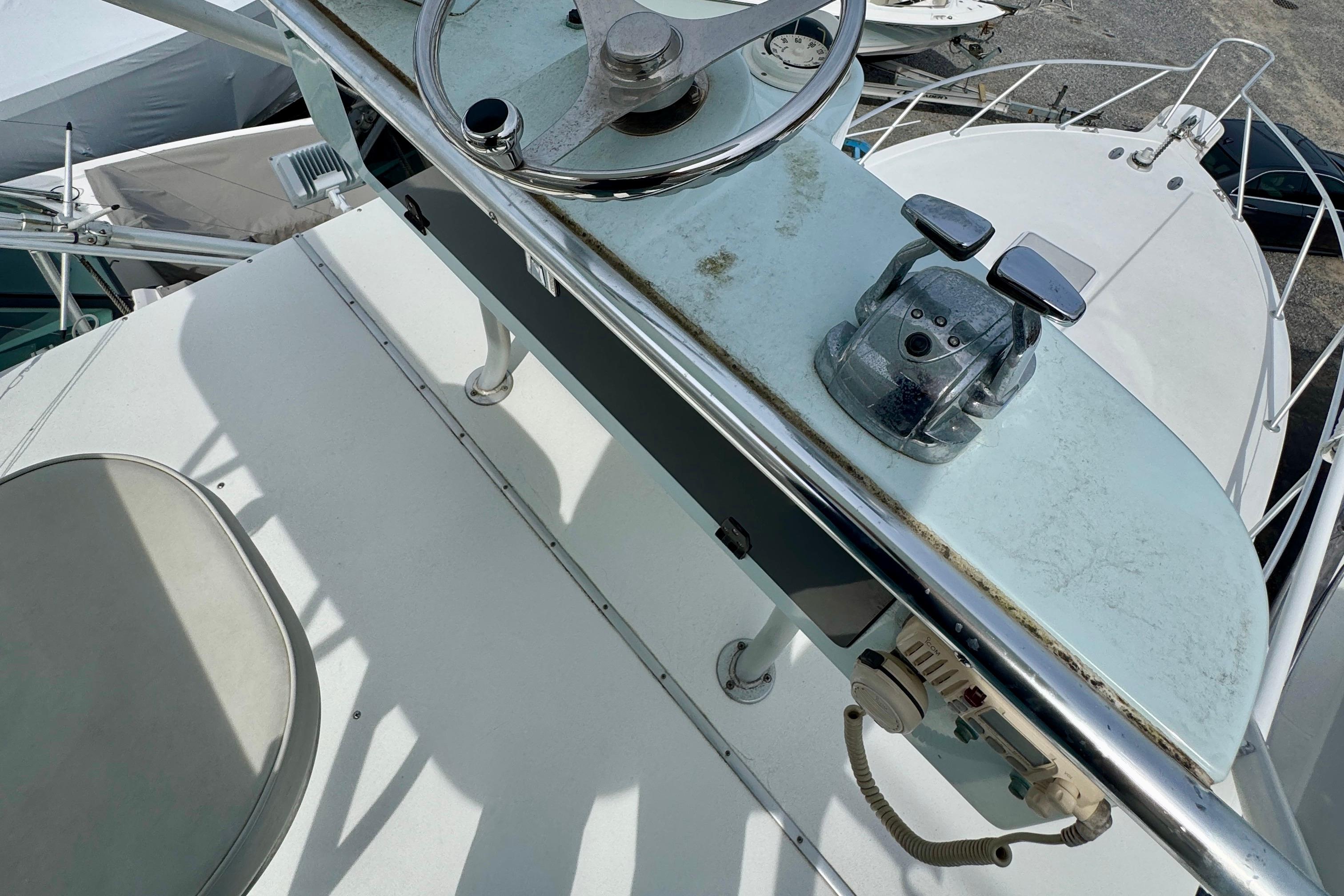 2004 Topaz 32 Express boat helm with steering wheel and throttle controls.