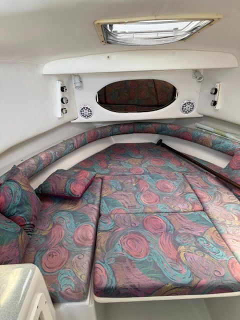 Interior of a 1995 Pro-Line 2950 Walkaround with colorful cushions and a porthole.