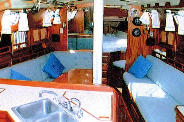 Interior of 1987 Ericson 38-200 sailboat with cozy seating and wooden finishes.