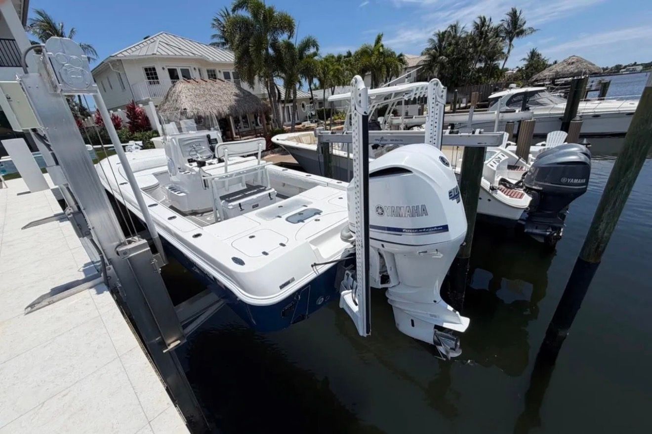 A 2016 Contender 25 Bay boat docked. It features a Yamaha outboard motor.