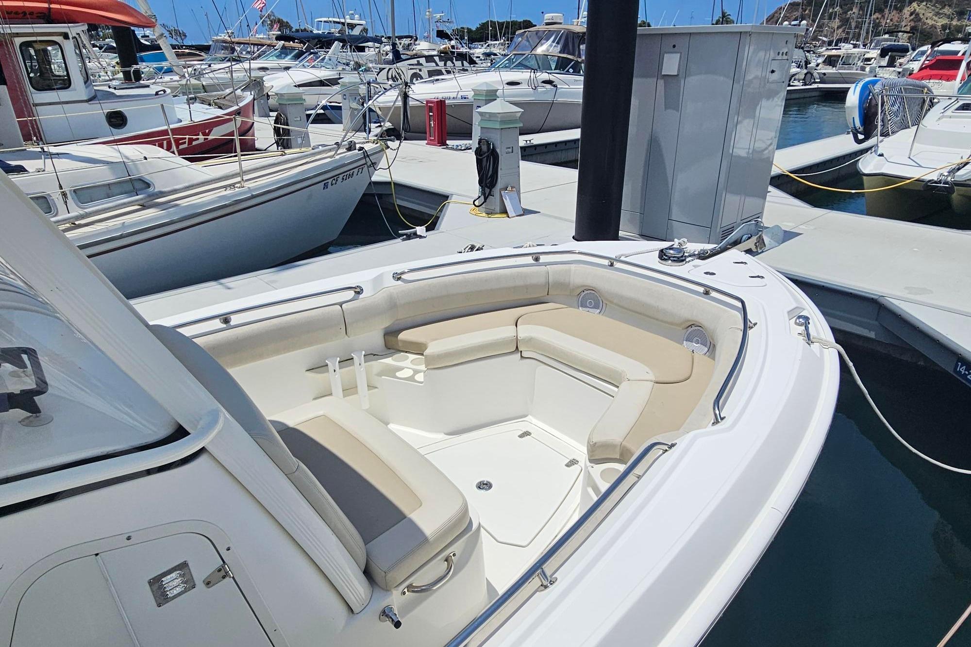 2017 Boston Whaler 230 Outrage boat docked in a marina, featuring spacious seating.