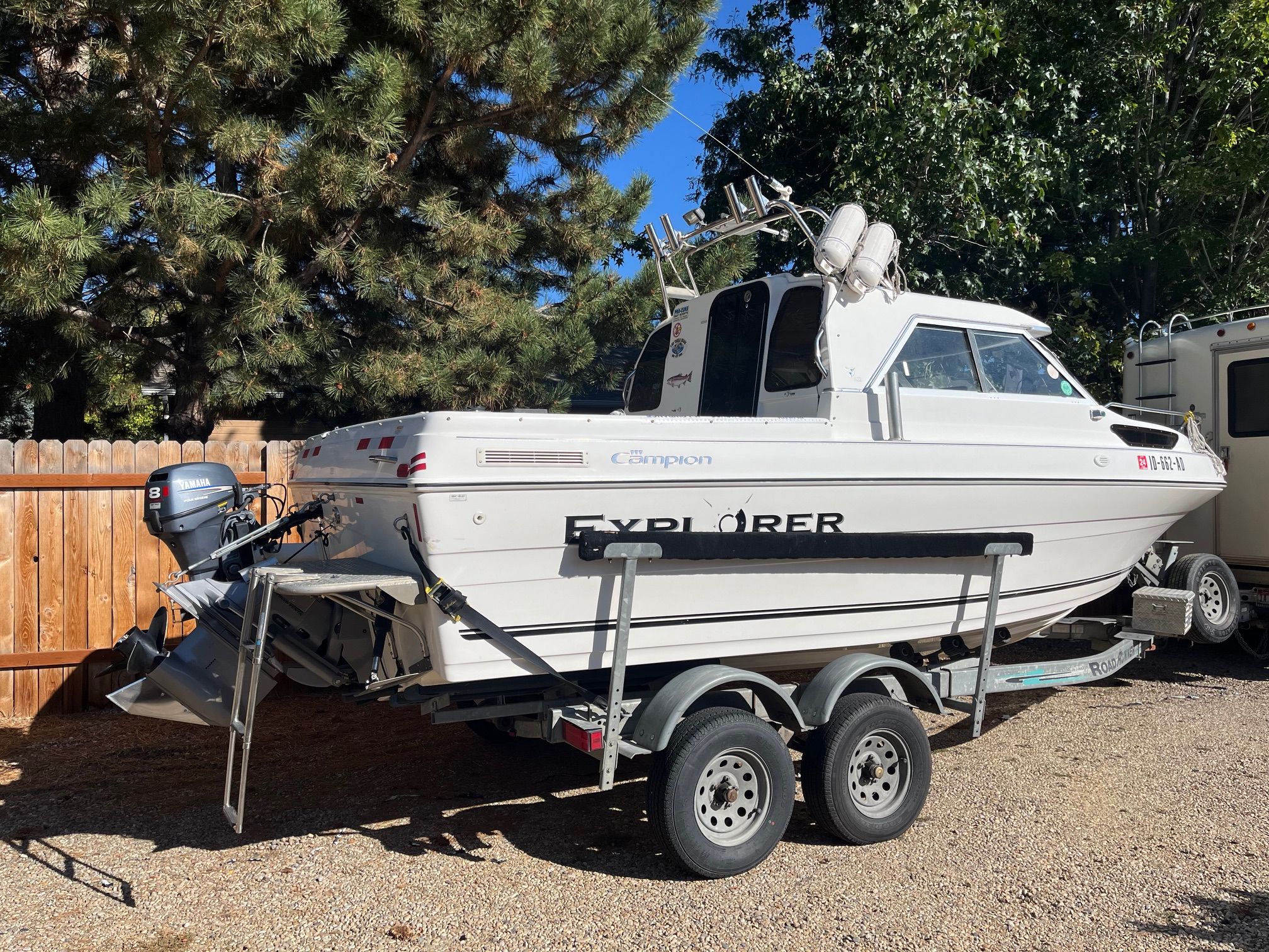 A 2002 Campion 622 Explorer boat on a trailer, surrounded by trees.