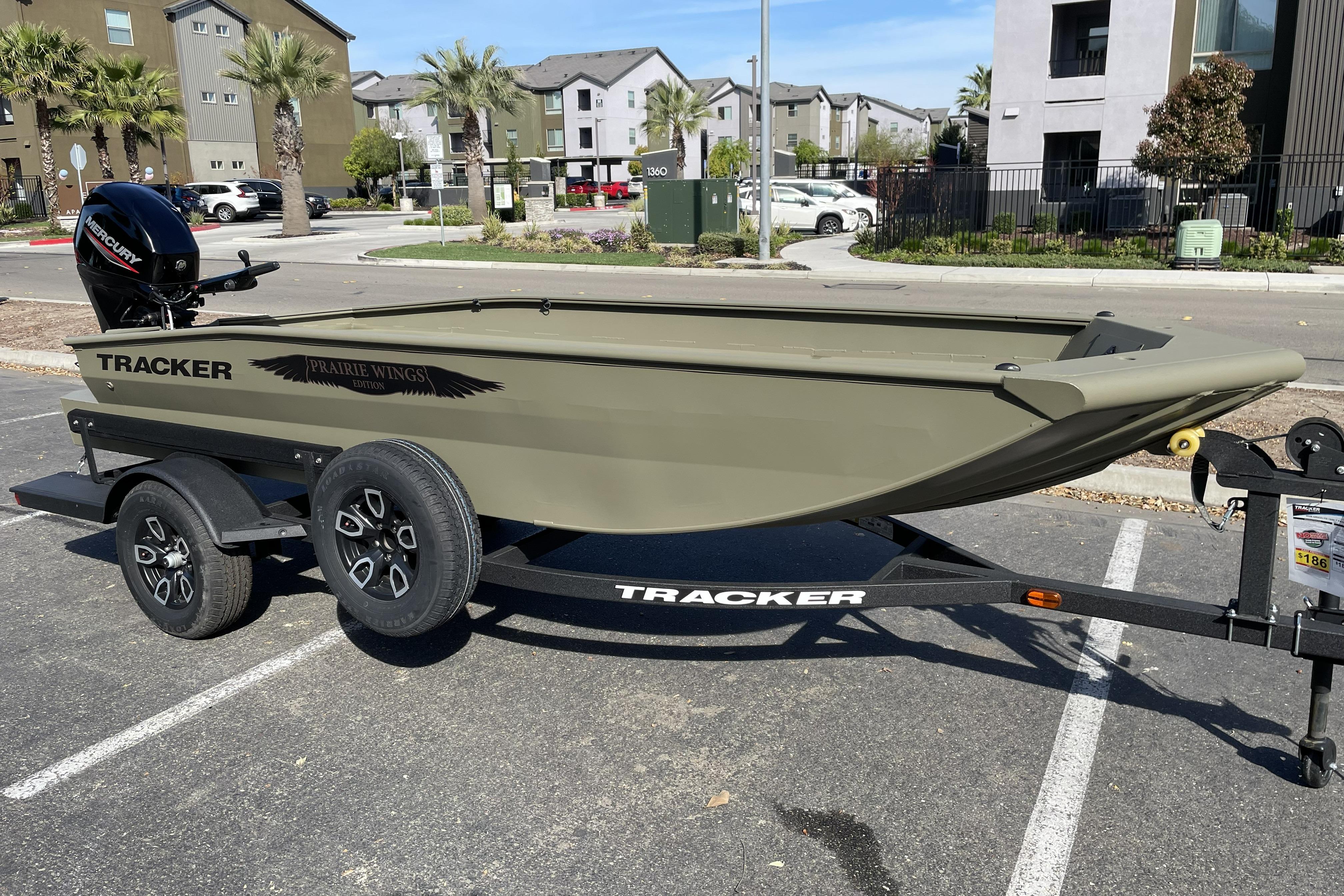 2026 Tracker Grizzly 1650 T Prairie Wings Edition boat on trailer in parking lot.