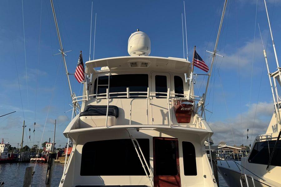 2002 Viking 61 Enclosed Bridge yacht docked with American flags.