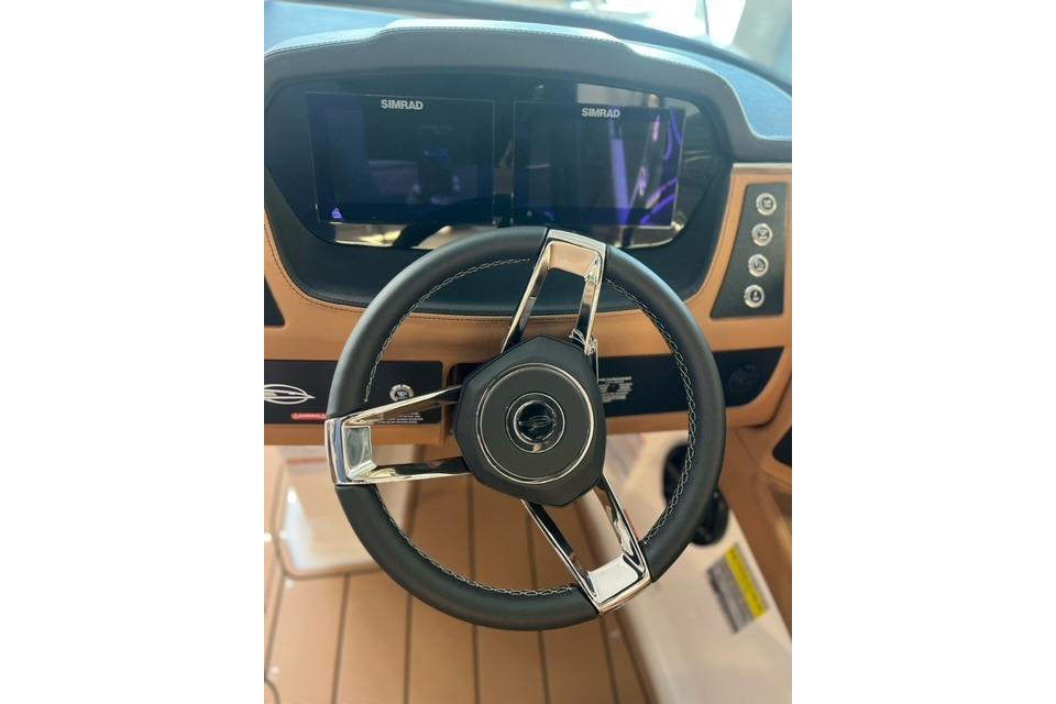 Steering wheel and dashboard of 2025 Chaparral 247 SSX boat with Simrad displays.