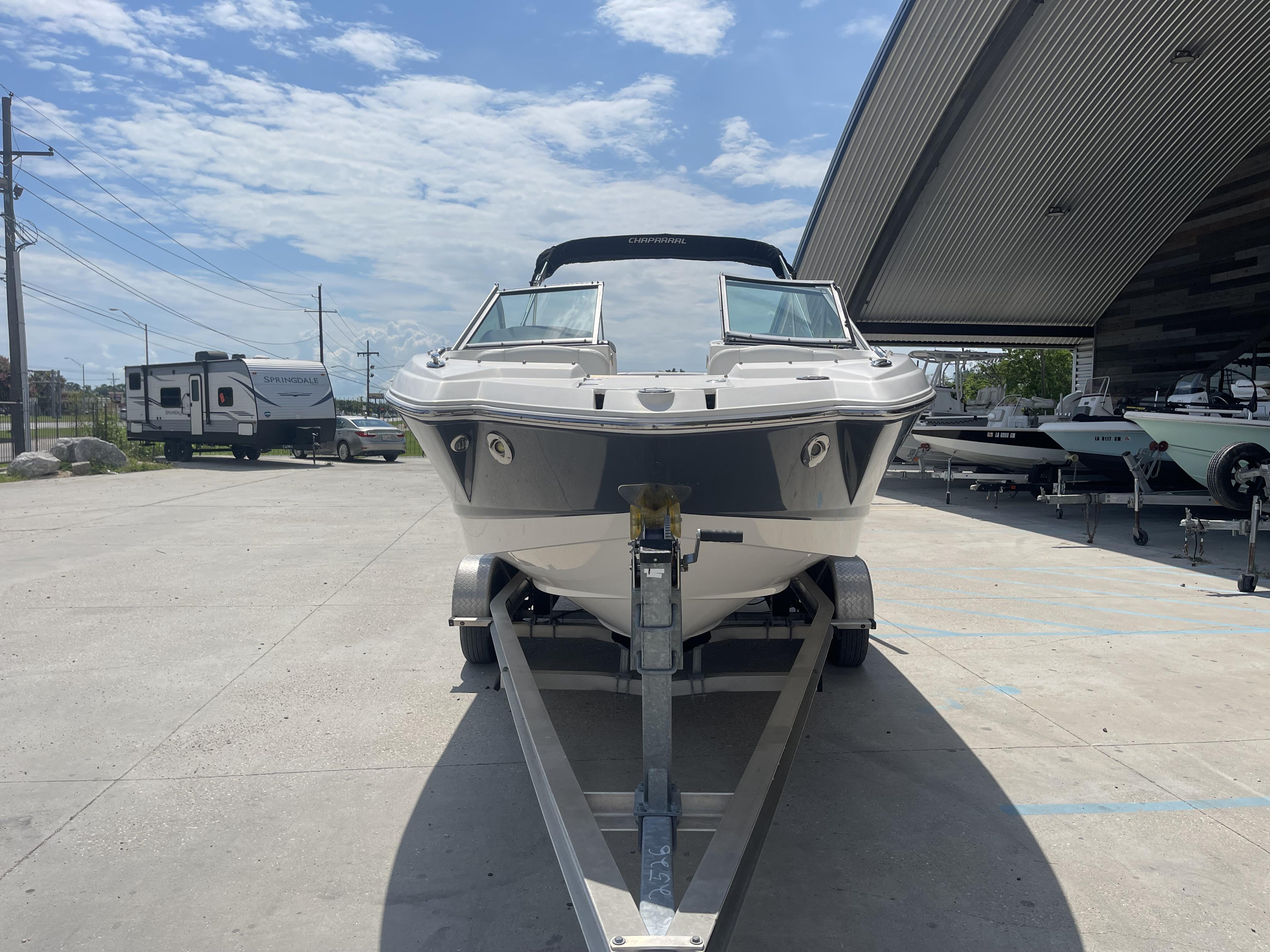 2014 Chaparral Sunesta 224 boat on trailer, parked outdoors under a clear sky.