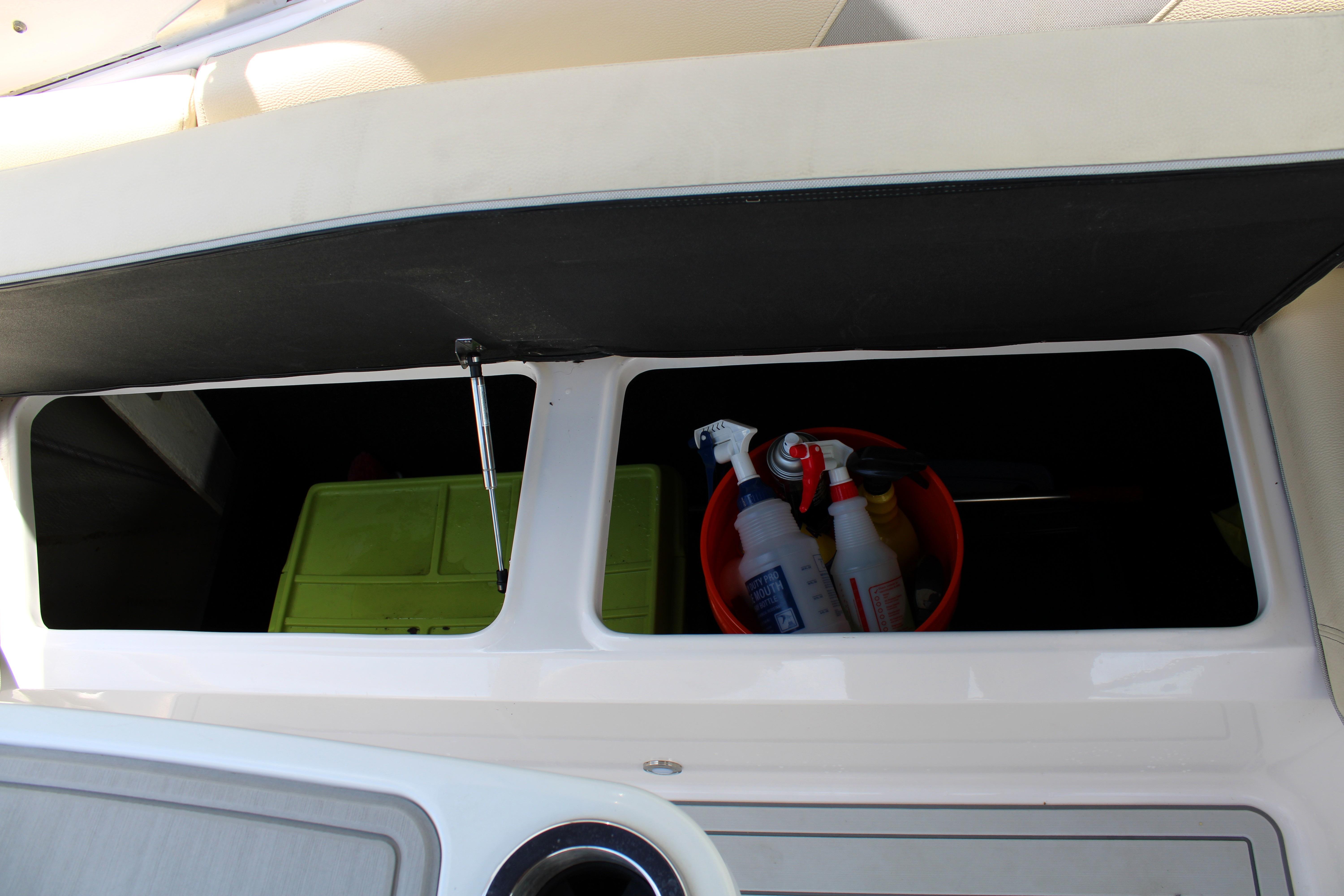 Storage compartment on a 2021 Regal 26 OBX boat with cleaning supplies.