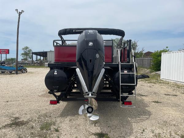 2023 Regency 250DL3 boat with powerful outboard motor, parked on gravel lot.