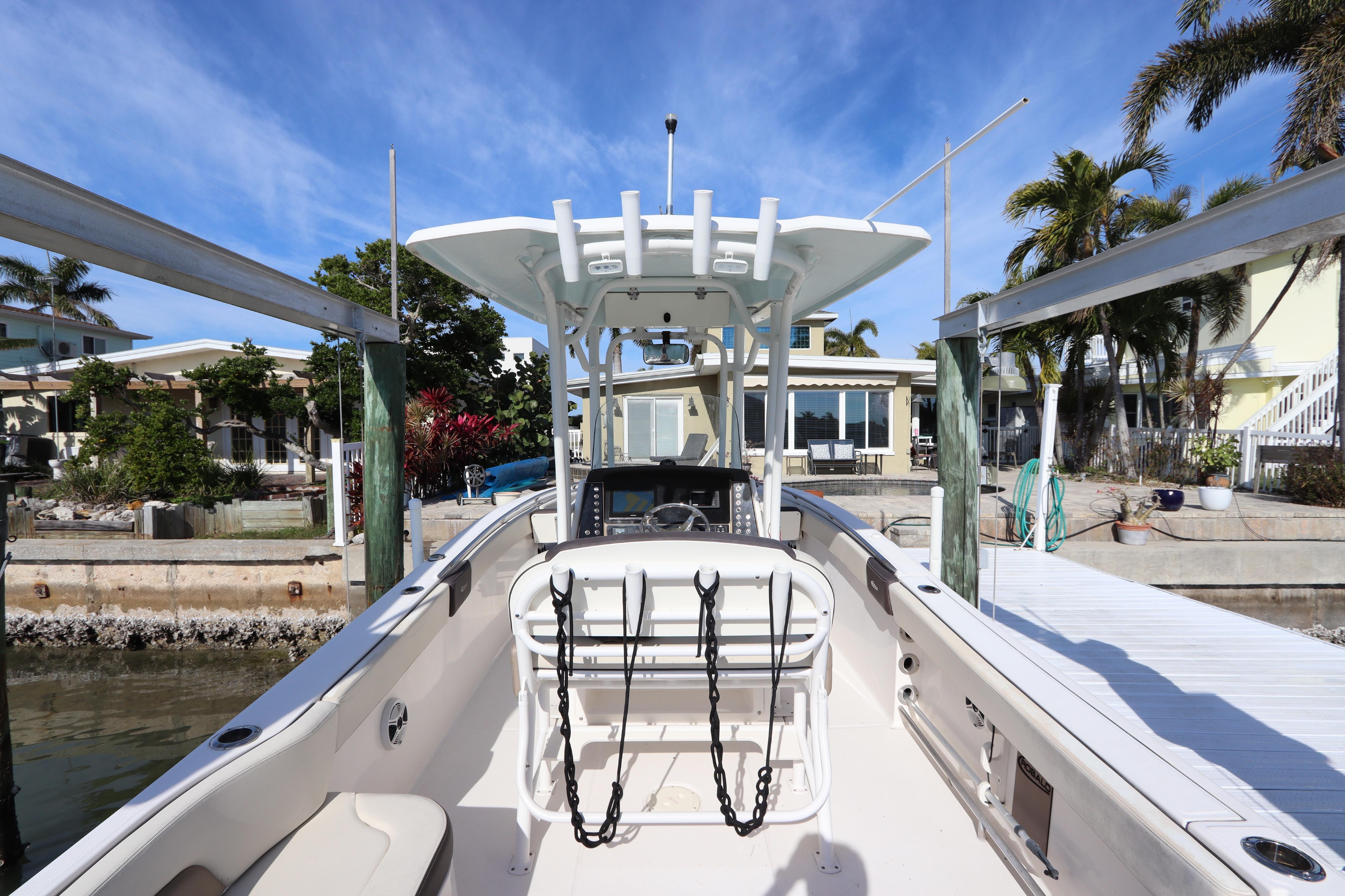 2019 Robalo R242 Center Console boat docked near waterfront homes.
