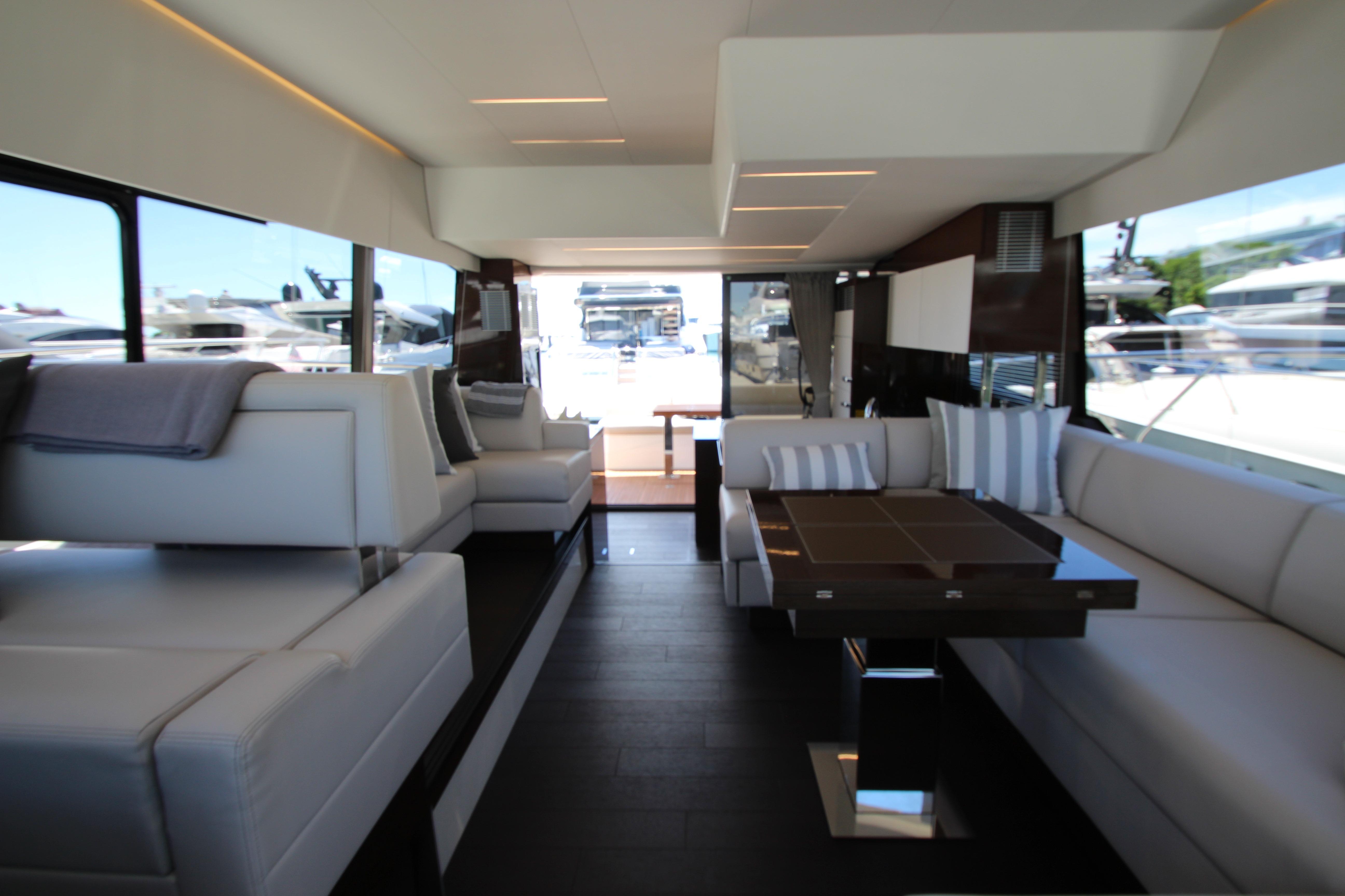 Luxurious interior of 2022 Prestige 520 yacht with modern seating and elegant design.