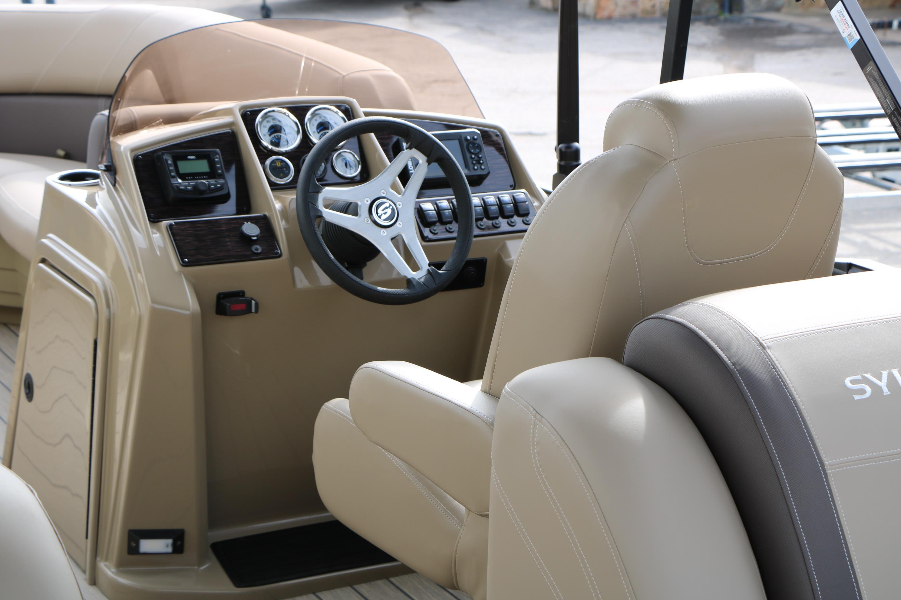 2026 Sylvan Mirage 822 LZ boat interior with steering console and beige seating.