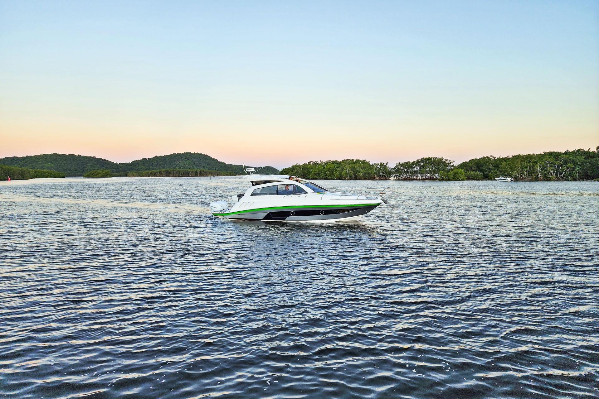 2026 Hanover 375 boat cruising on a serene lake at sunset.