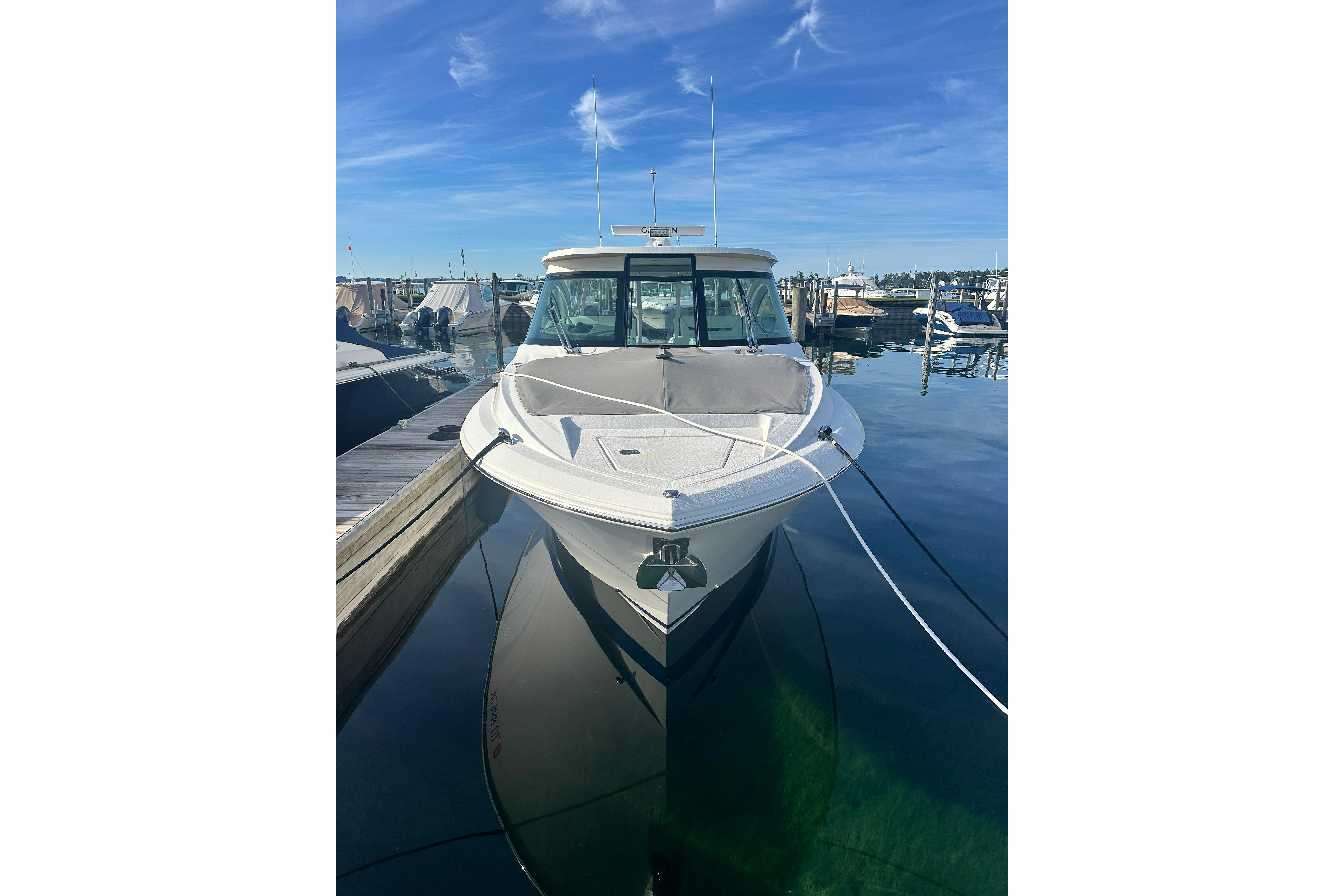 2021 Tiara Yachts 34 LX docked at marina under clear blue sky.