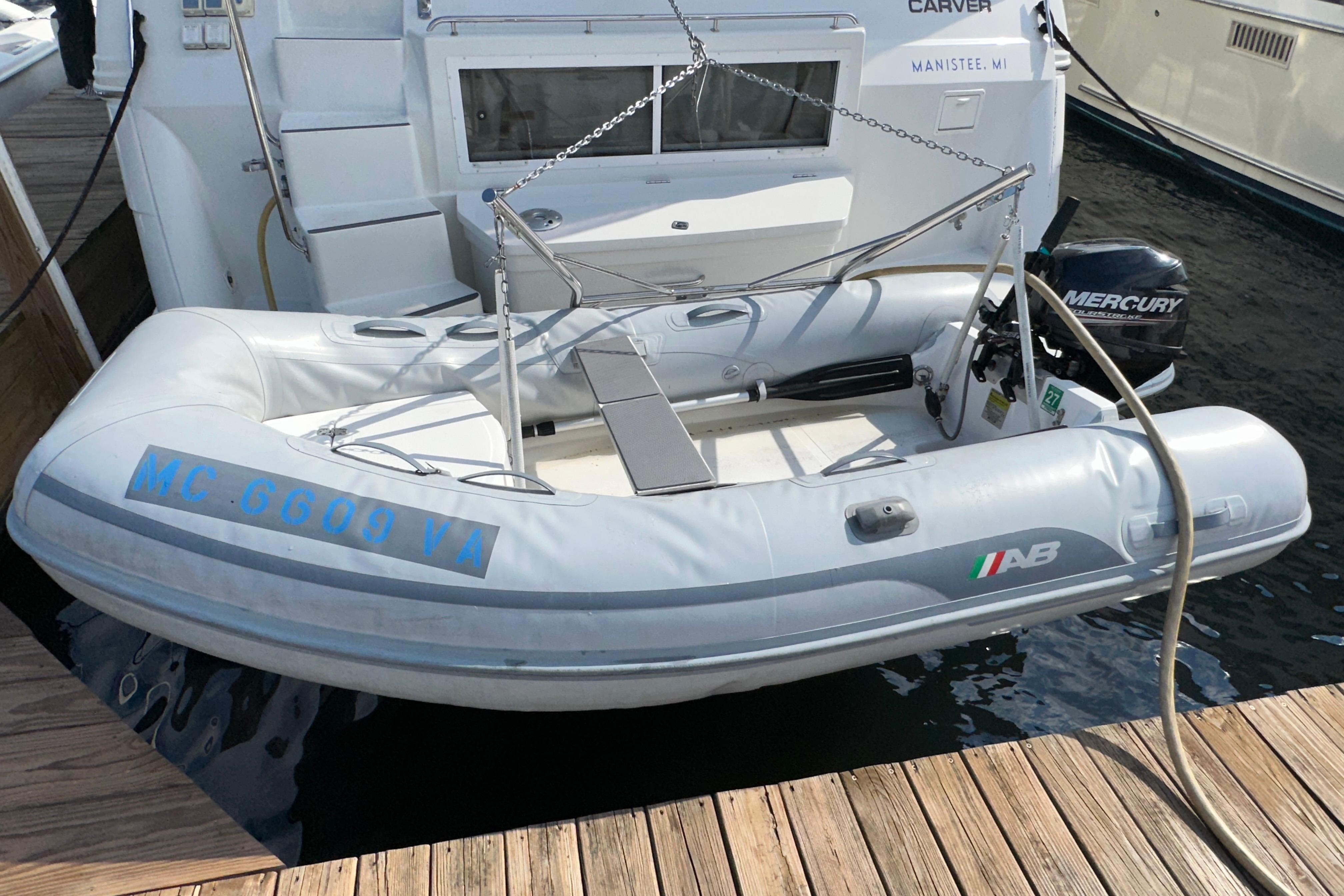 Inflatable boat with Mercury motor docked beside 1998 Carver 445 Aft Cabin Motor Yacht.