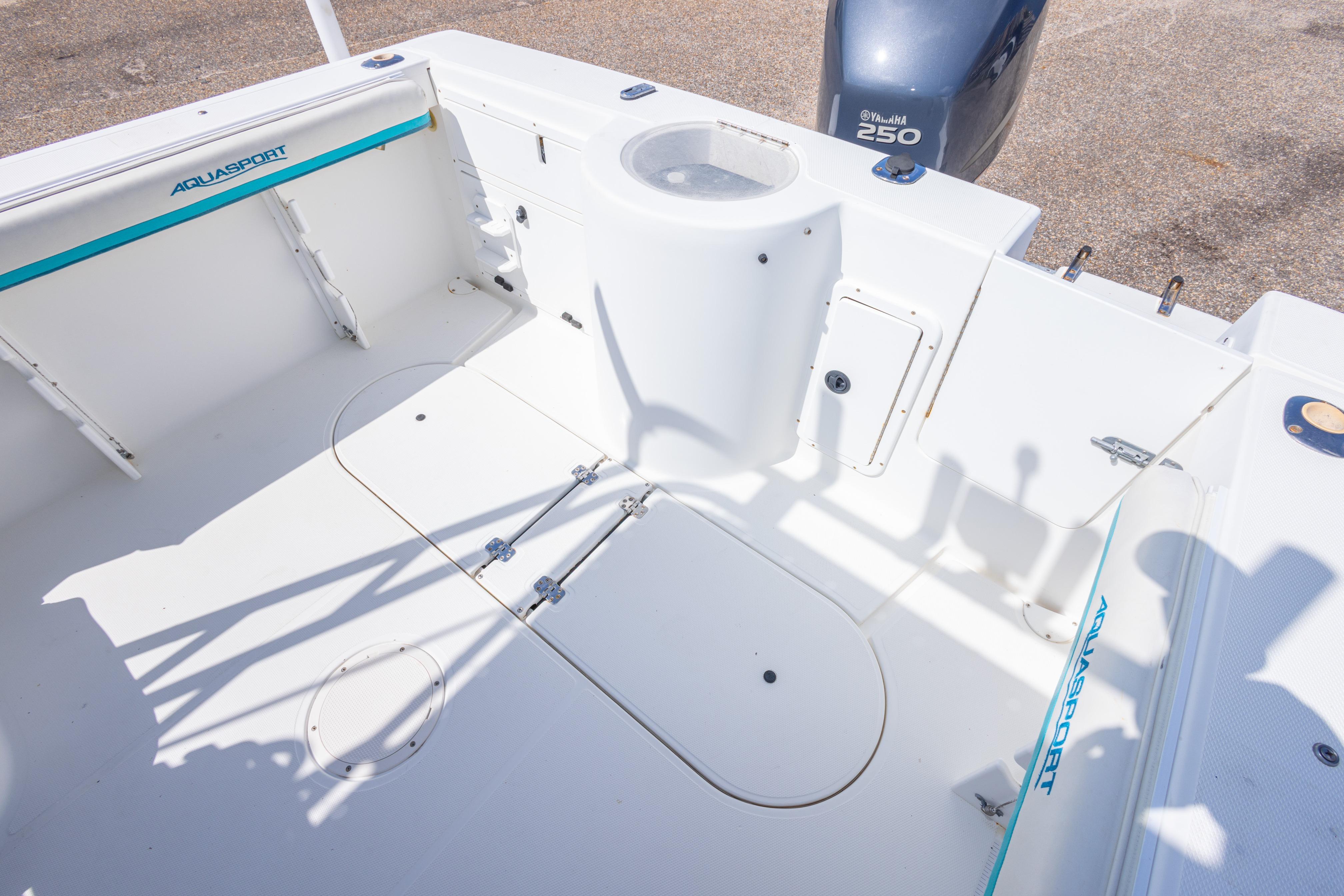 1999 Aquasport 225 Explorer boat interior with Yamaha 250 engine, showcasing spacious deck layout.