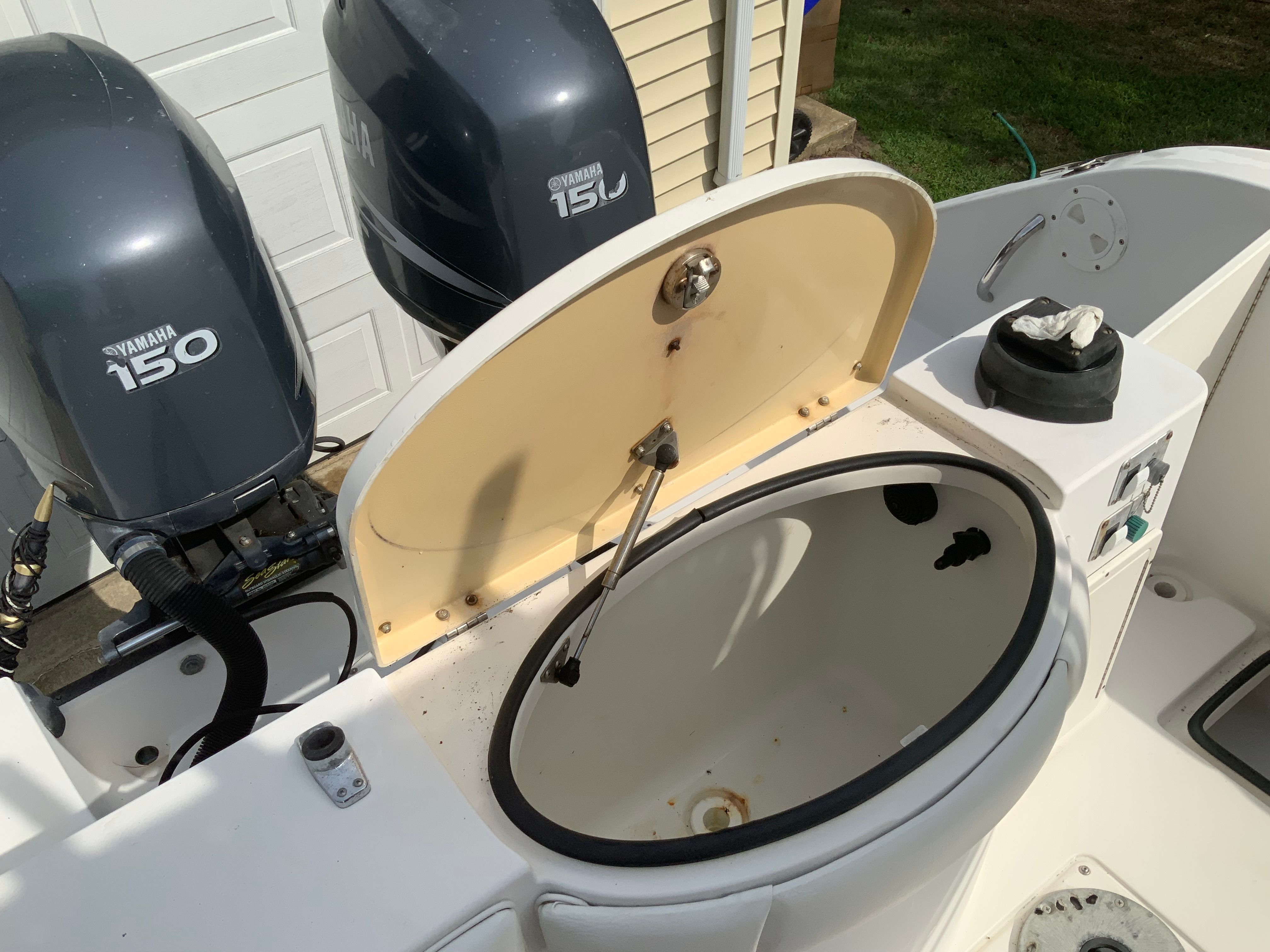 Two Yamaha outboard motors are mounted on a boat. An open compartment is visible.