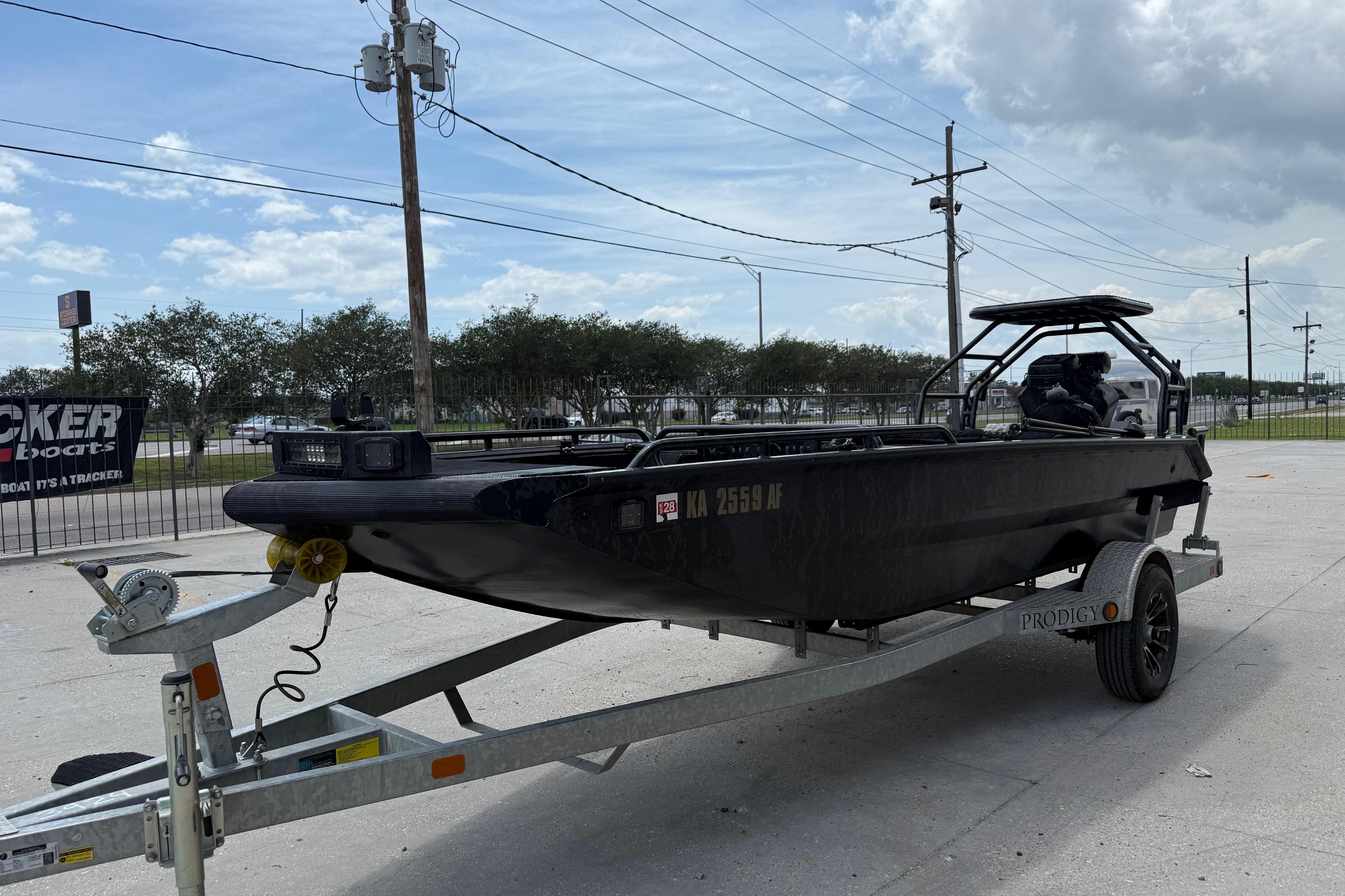 2024 Prodigy 17 boat on trailer, parked outdoors under a cloudy sky.