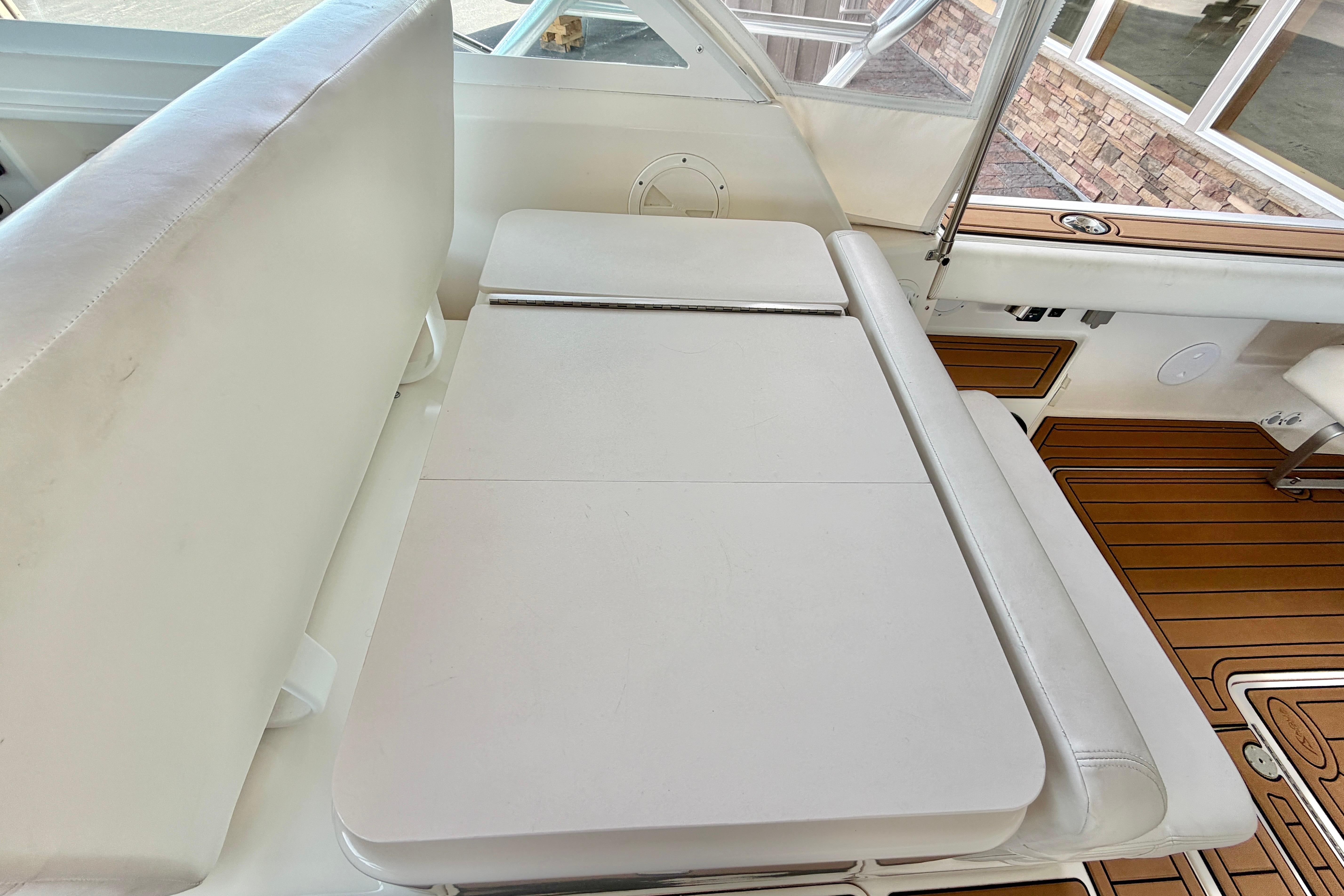 1999 Tiara Yachts 2900 Coronet interior with white seating and wooden flooring.
