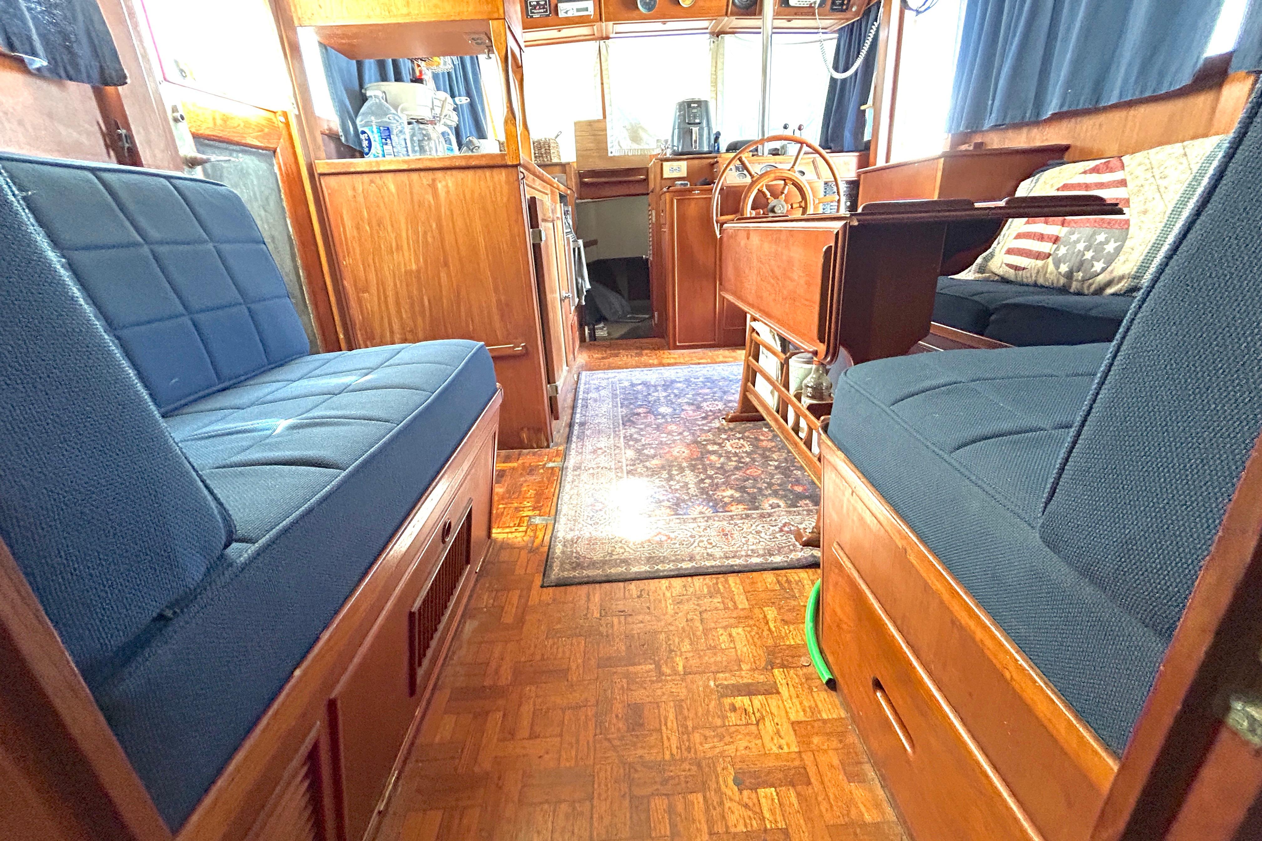 Interior of 1988 Grand Banks 36 Classic yacht with wooden furnishings and blue seating.