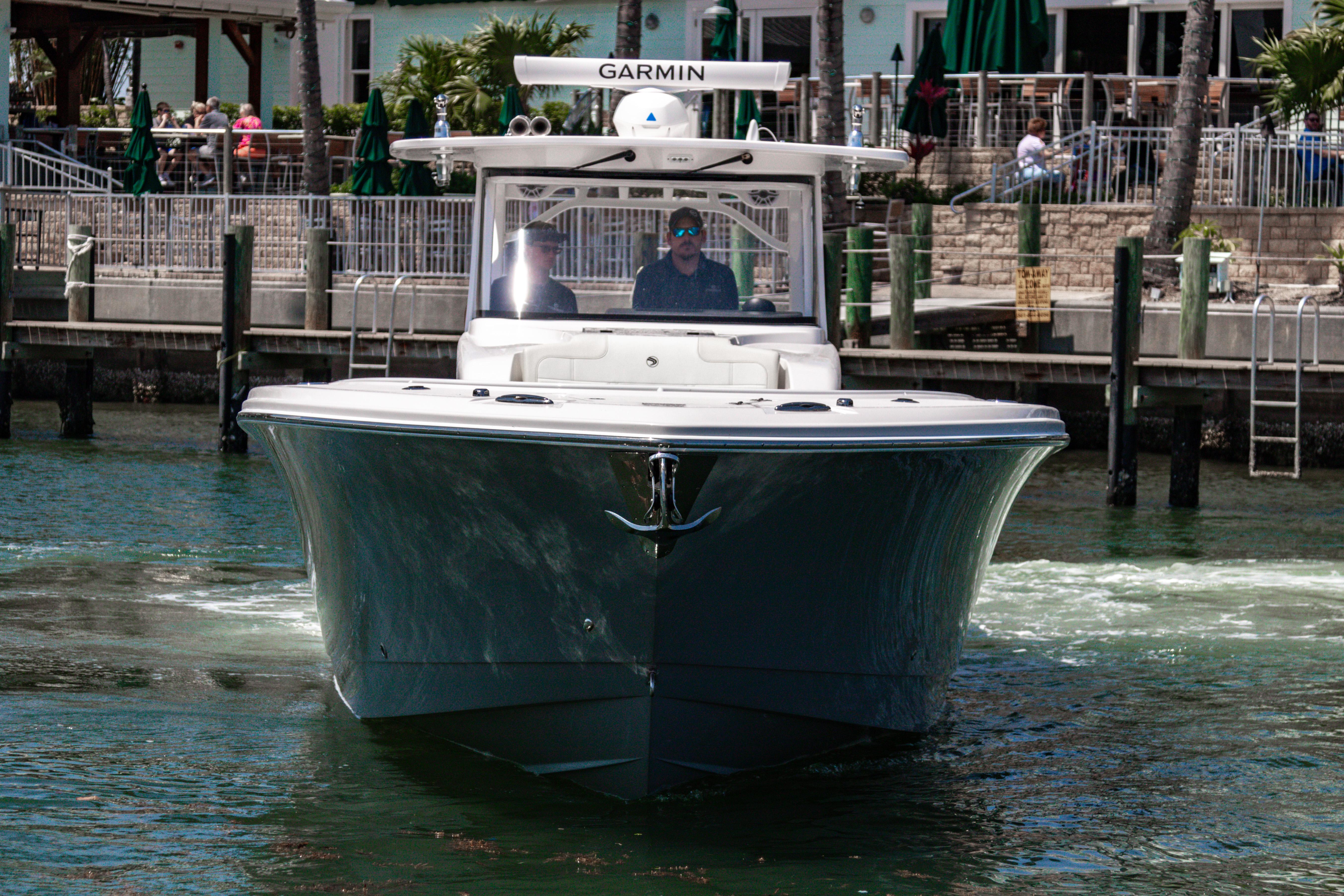 2025 Edgewater 370CC boat navigating a marina, featuring Garmin equipment.