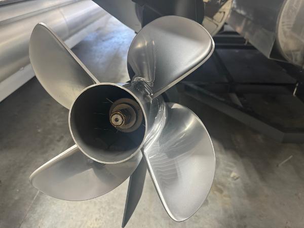 Close-up of a 2025 Manitou LX boat propeller in a workshop setting.