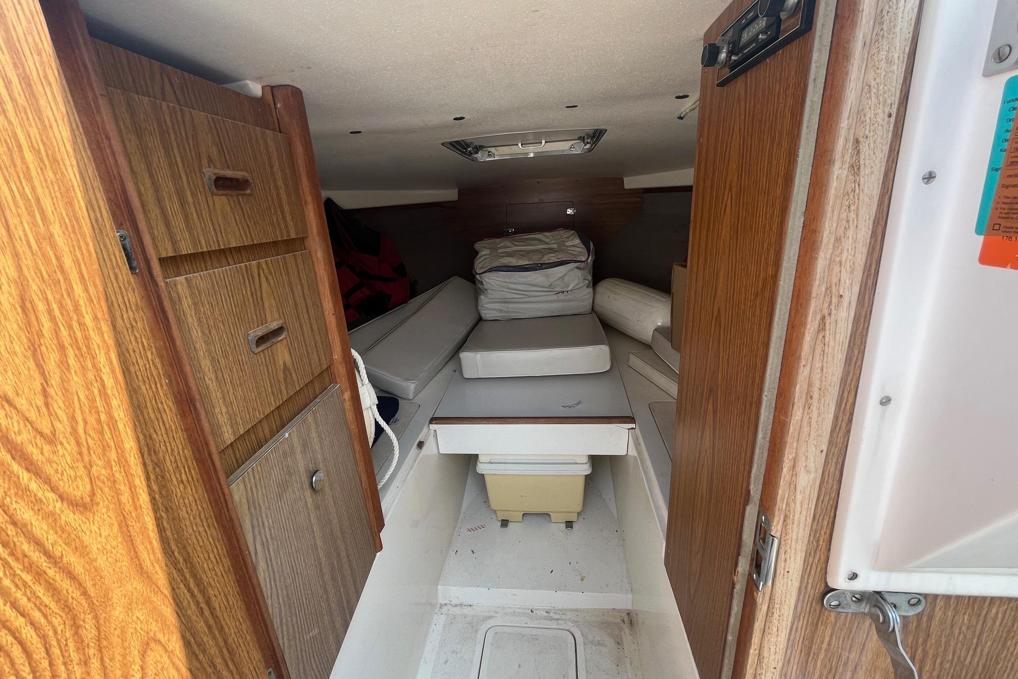 Interior cabin of a 1975 Bertram 26 Moppie boat with wooden cabinetry.