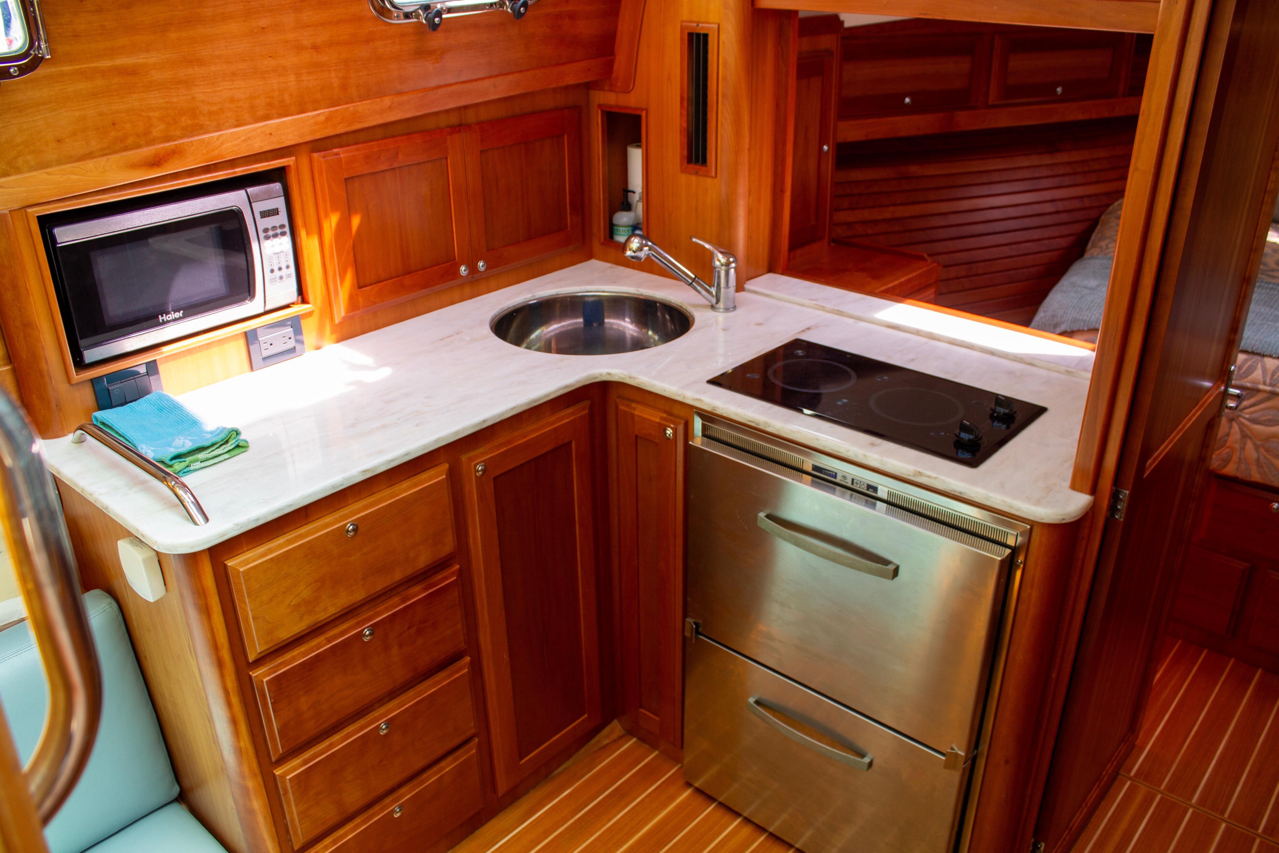 Luxurious 2013 Sabre 38 Salon Express yacht kitchen with modern appliances and elegant wood cabinetry.