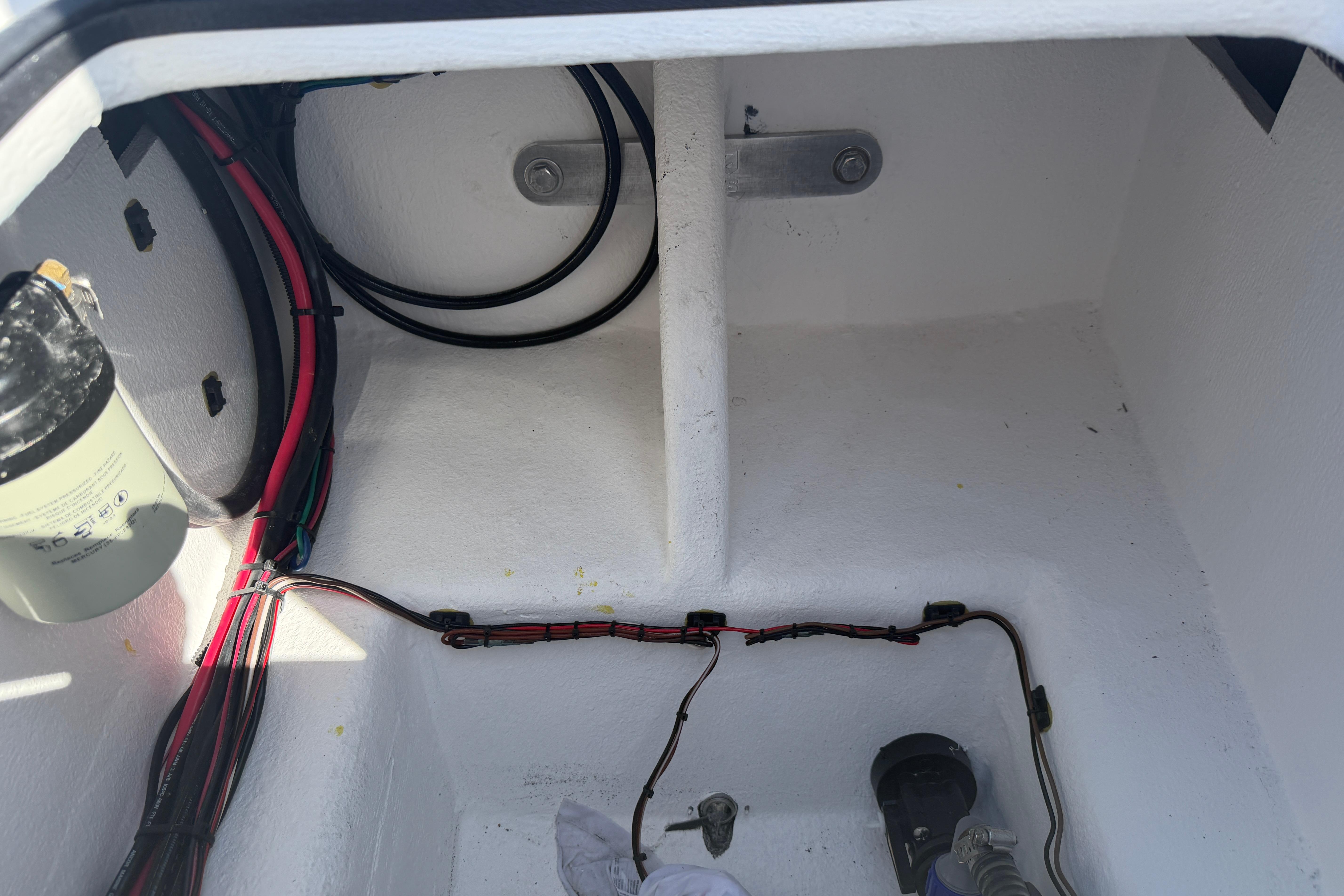 Interior view of a 2026 Skuta 24 Cat boat compartment with wiring and components.